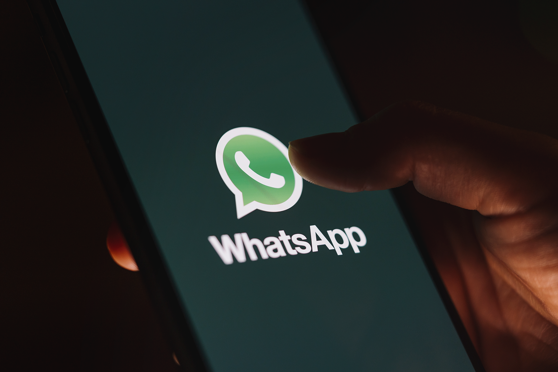 A person holding a cell phone with the WhatsApp logo displayed on screen. This image is being used as the thumbnail for a blog on WhatsApp business marketing