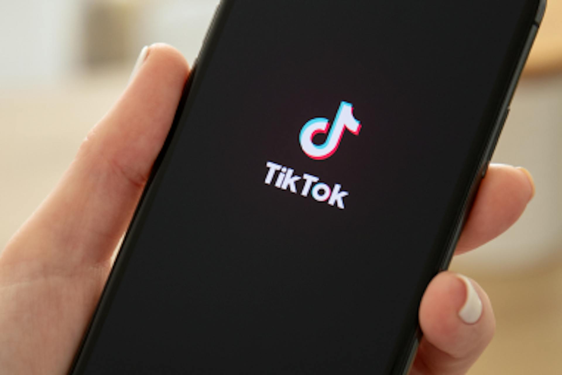 Hand mit Smartphone mit TikTok App