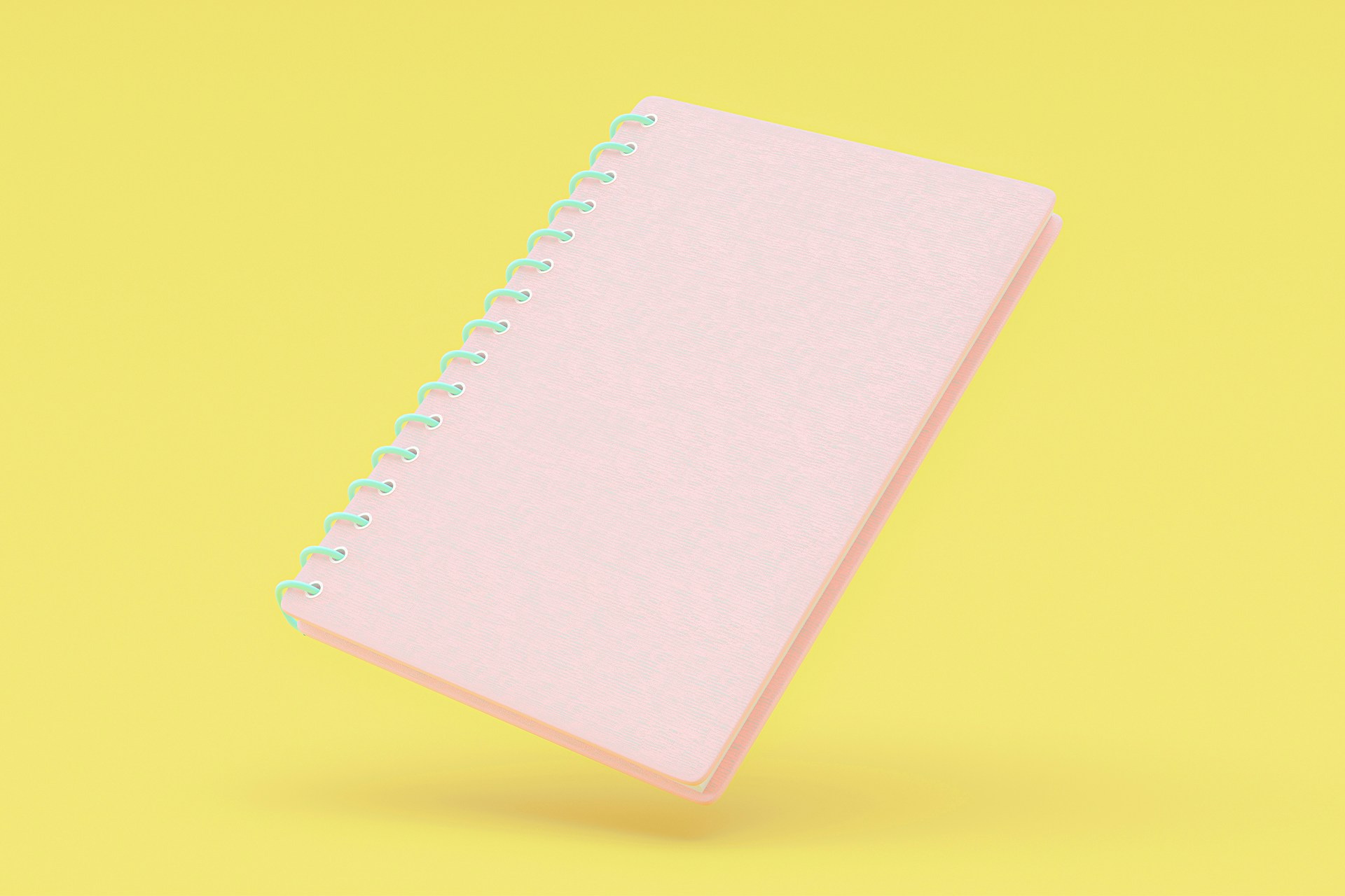 Light pink notebook on yellow background. 10 steps to writing a communication plan blog post
