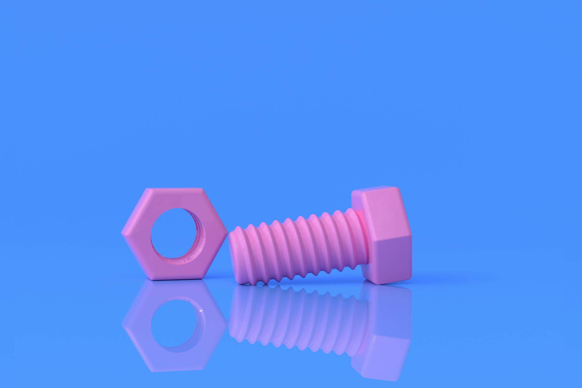 An image of a pink metal nut and bolt on a solid blue background. When building a branding guide, you'll need the right tools — and this blog explains the nuts and bolts of putting together an impactful strategy. 
