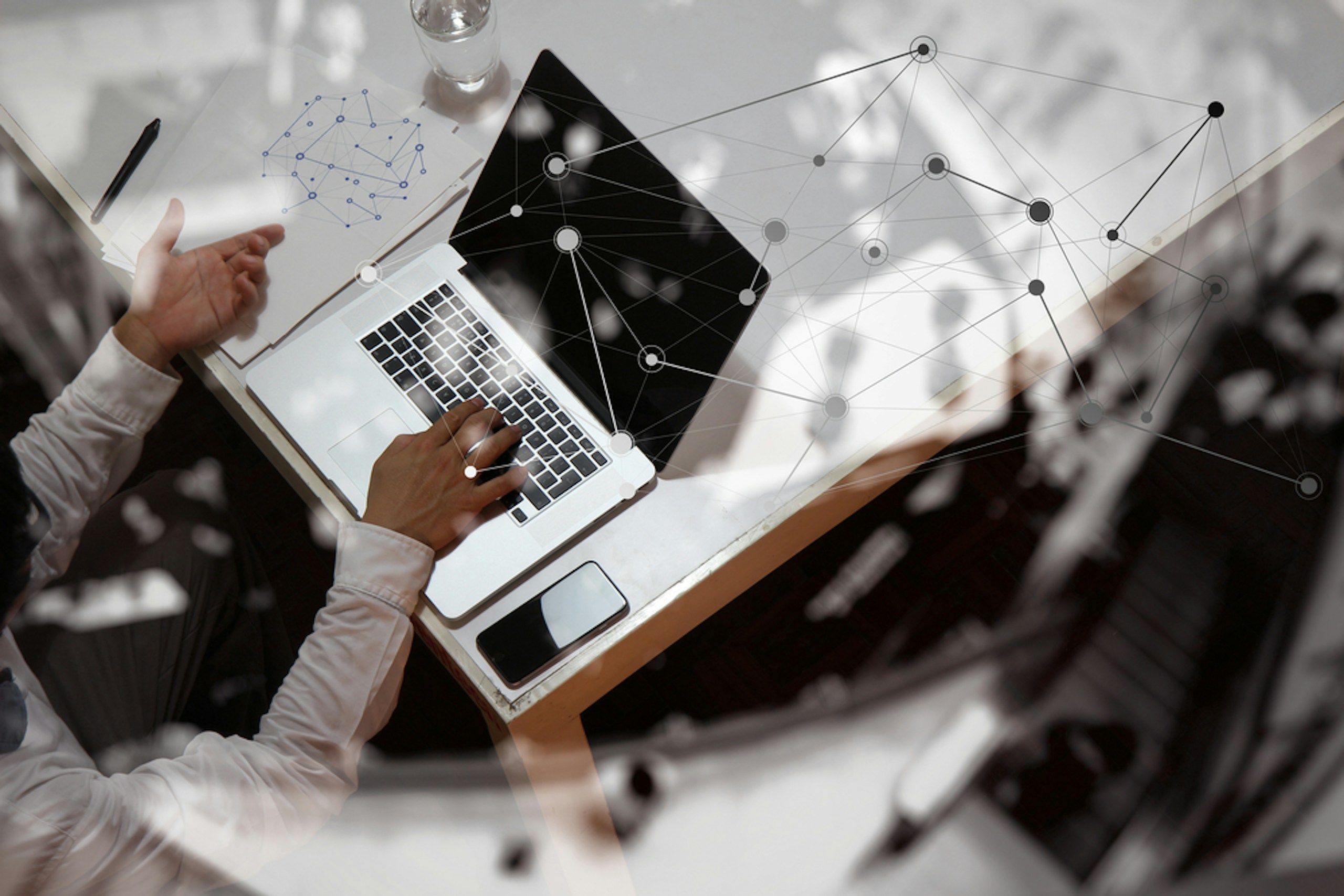 Ein Mann arbeitet am Laptop mit analytischen Elementen - eventuell führt er gerade eine Branchenstrukturanalyse nach Porter durch.