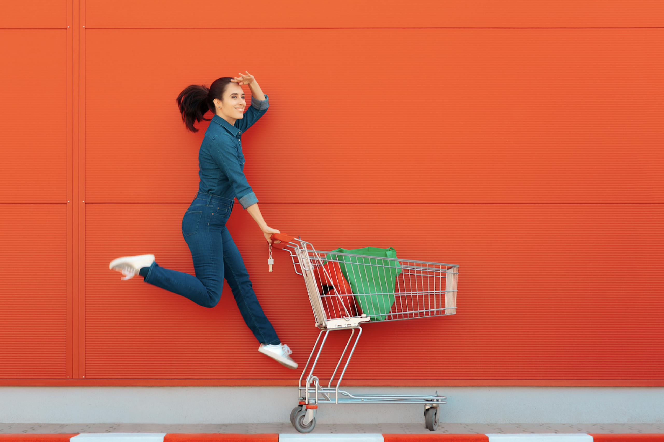 Femme sur fond orange qui saute avec un cadis