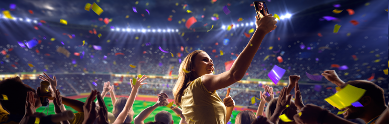 A woman at a sporting event taking a selfie