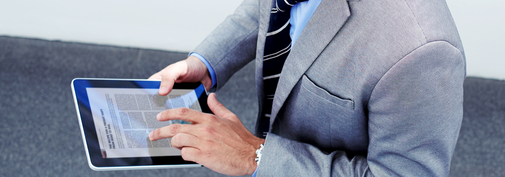 man in a suit holding an ipad