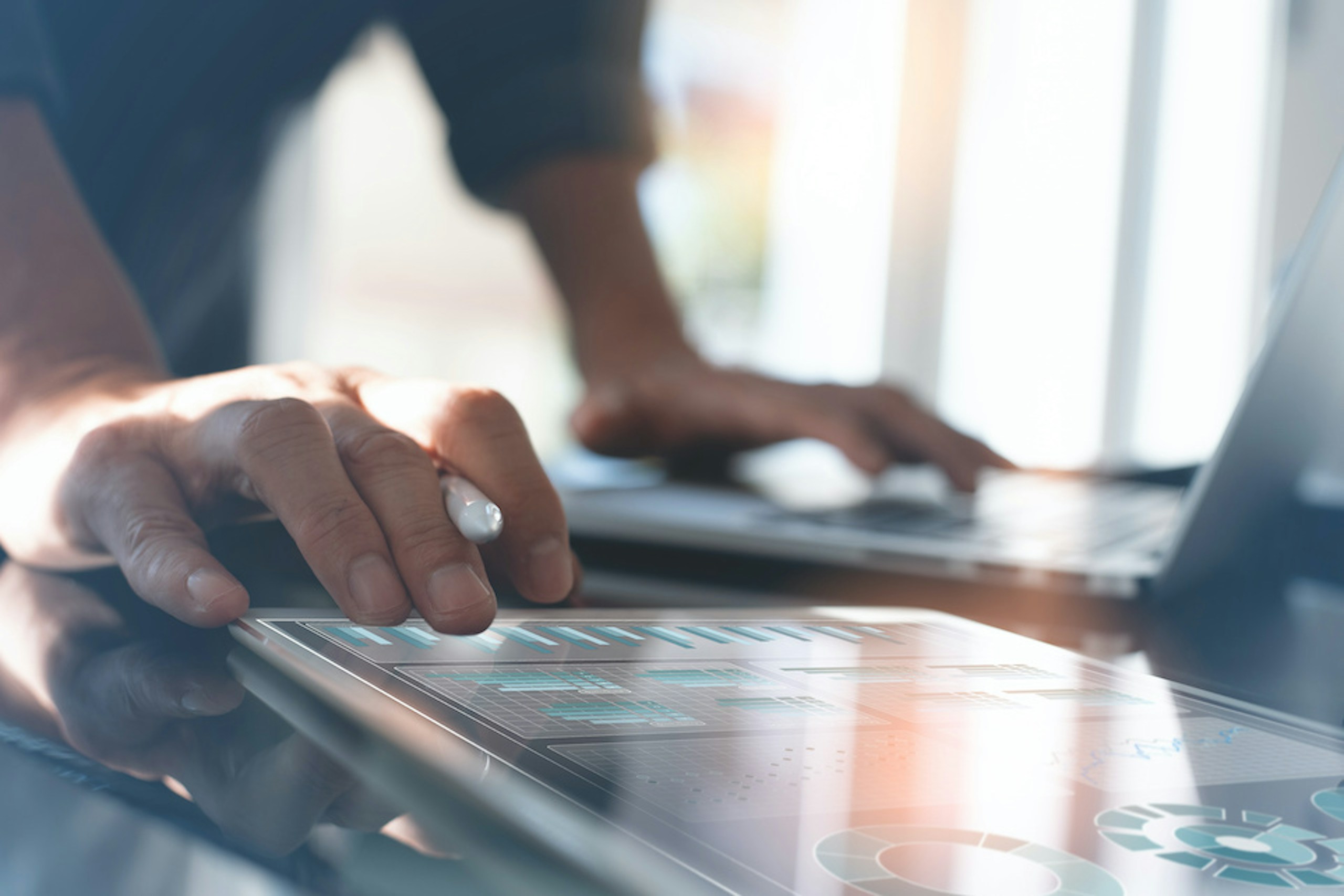 Nahaufnahme der Hände eines Mannes, der mit einem Tablet mit Social Media KPI Analysen arbeitet