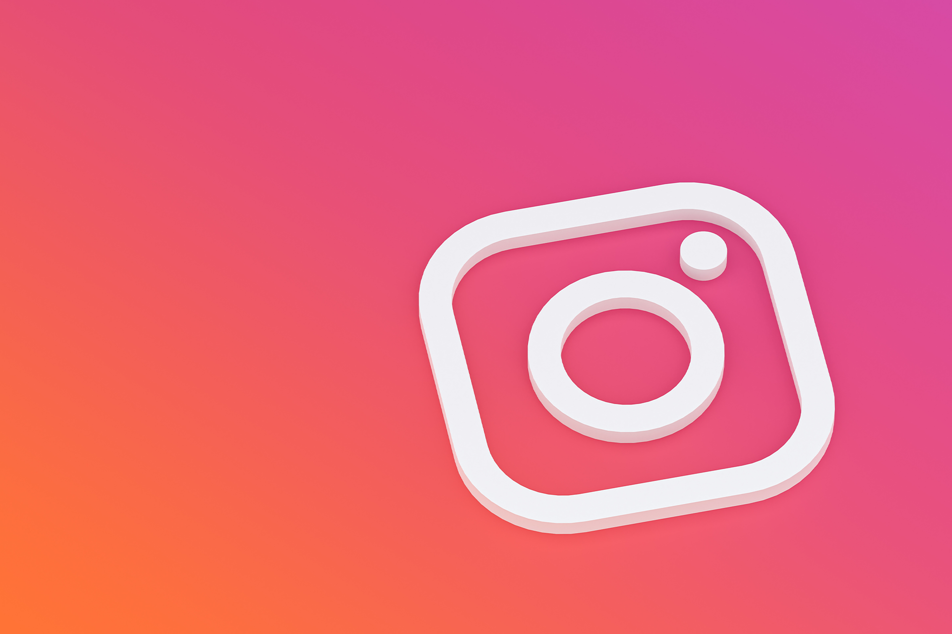 Un logo Instagram blanc posé sur un fond couleur orange, violet et rouge caractéristique du réseau social.