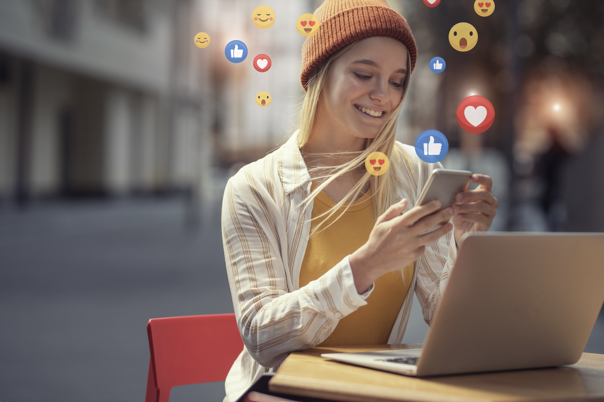 Femme tenant son téléphone et regardant des contenus avec des emojis