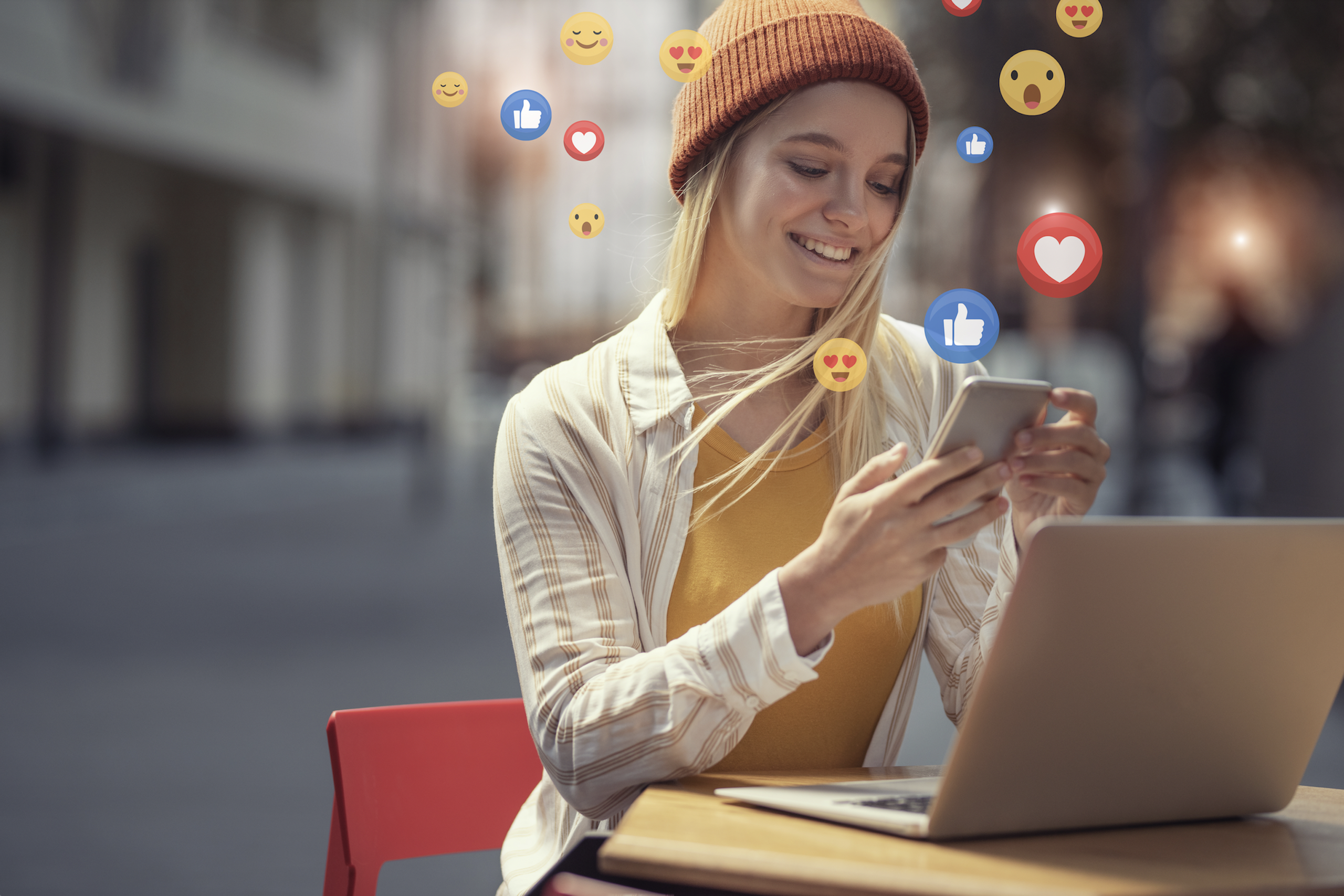 Femme tenant son téléphone et regardant des contenus avec des emojis