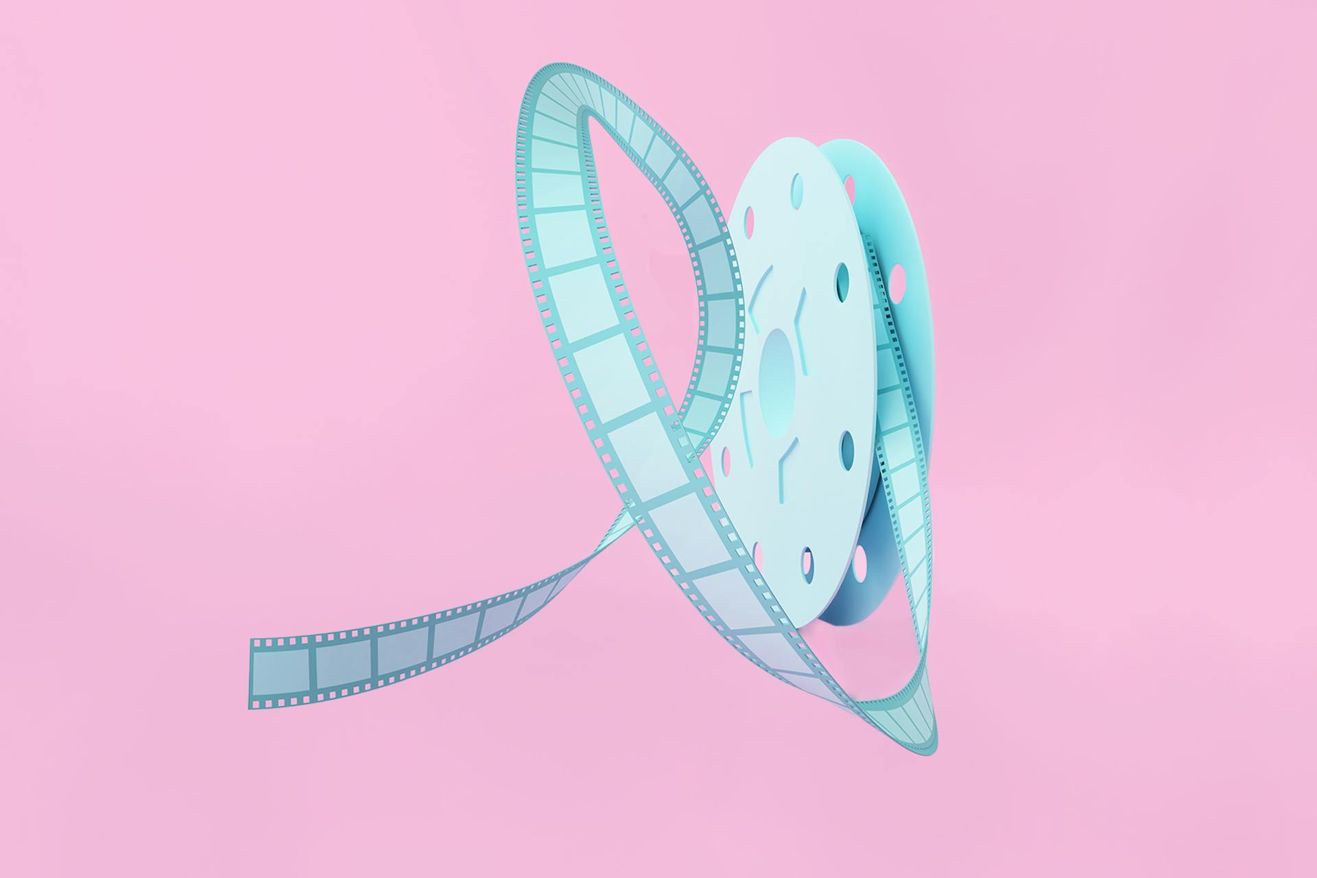 Image of a light blue old-fashioned film reel with film coming out, on a pink background. How to create and use Instagram Reels blog post