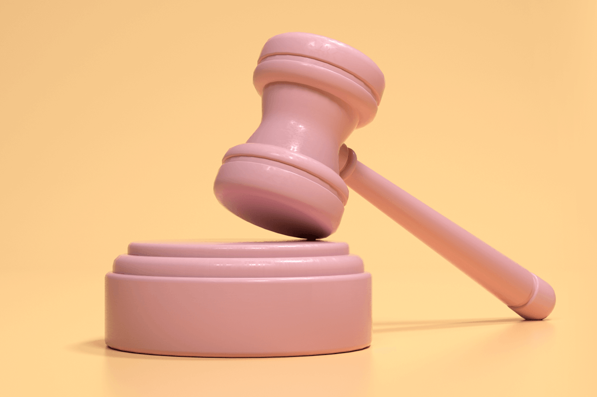 3D Illustration eines rosa Richterhammers vor einem gelben Hintergrund, um die Wichtigkeit einer Single Source of Trutz (SSOT) zu demonstrieren