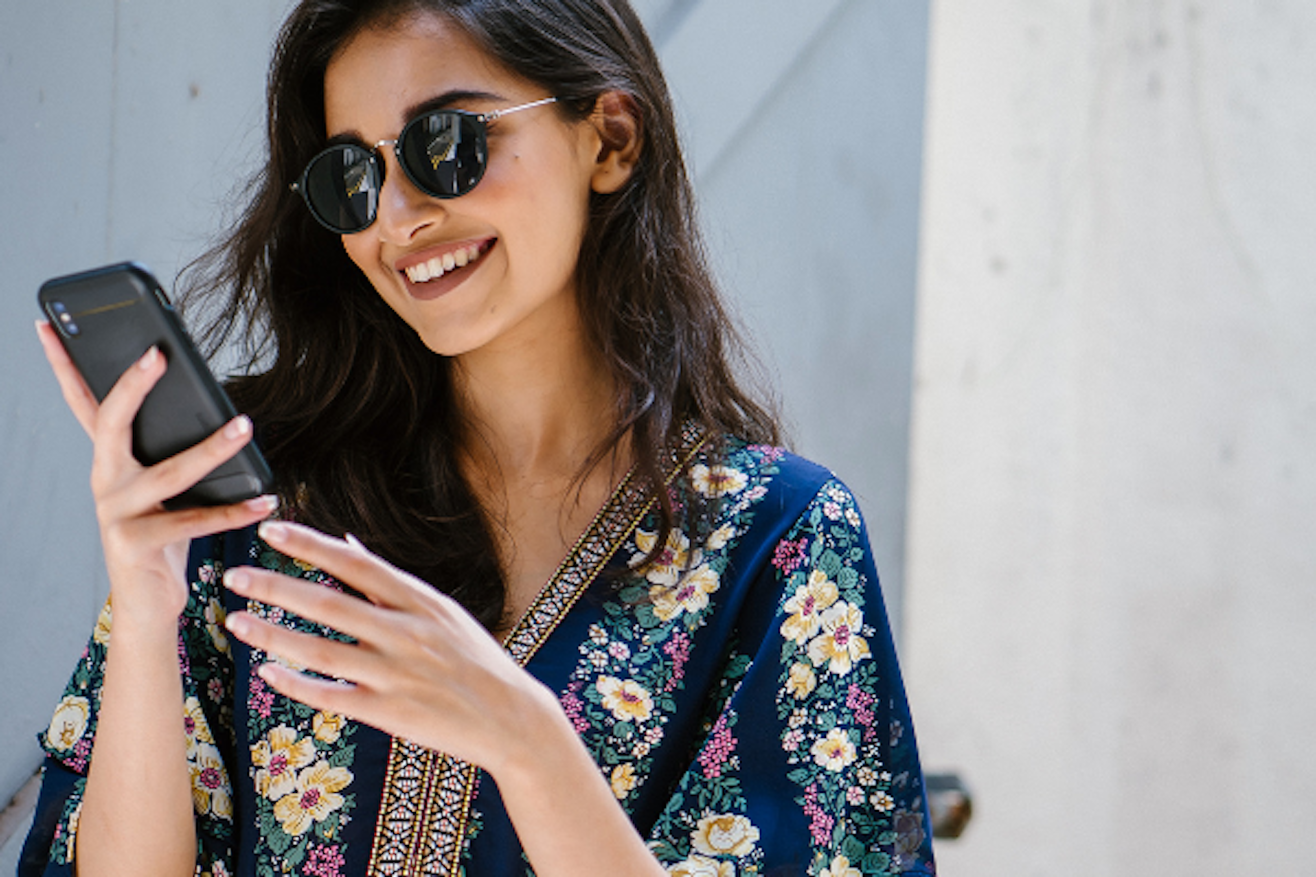 Photo of a woman smiling into her smartphone