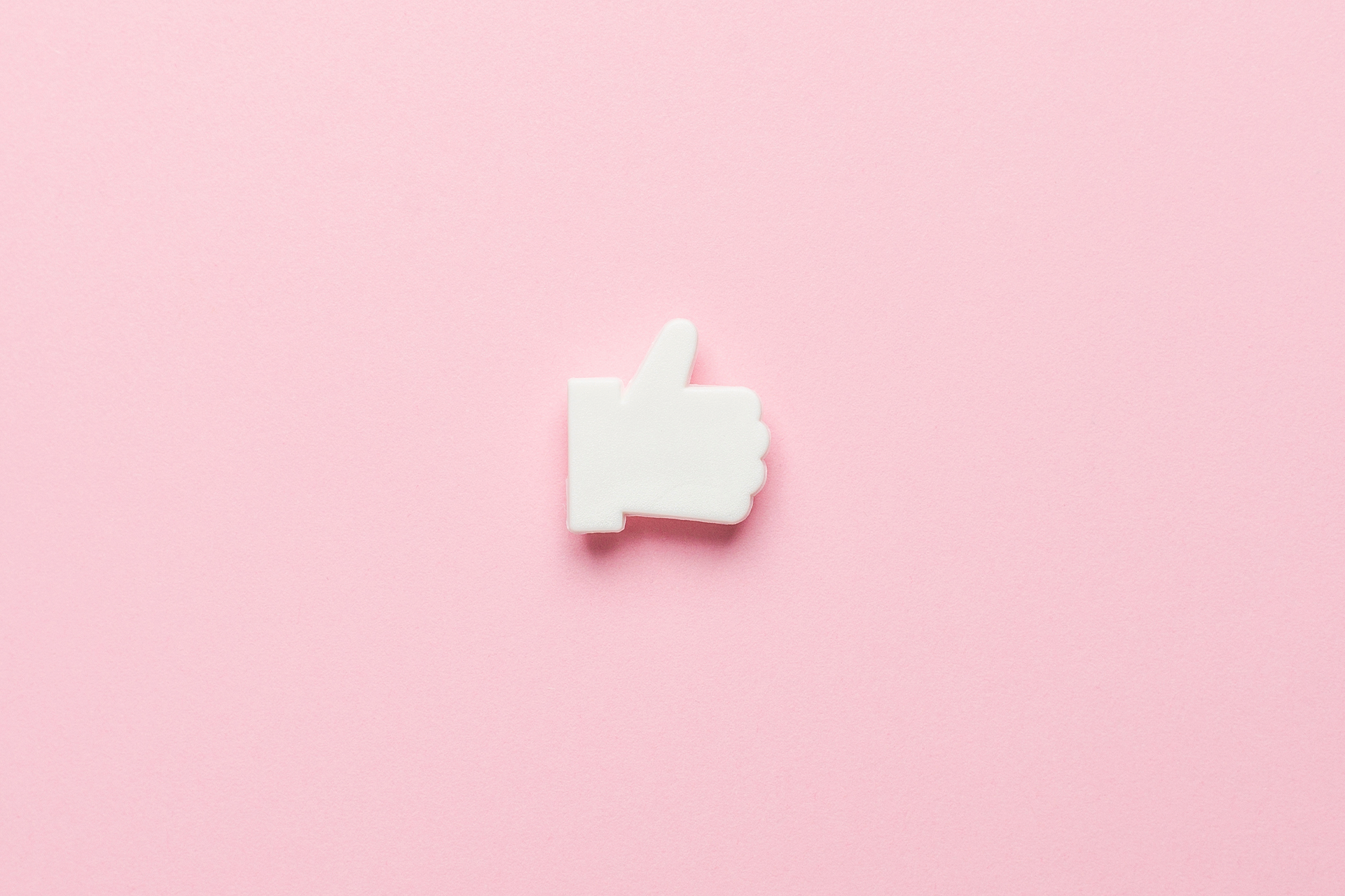 Facebook thumbs up "like" icon on pink background. Blog post: how to get more likes on your business Facebook page