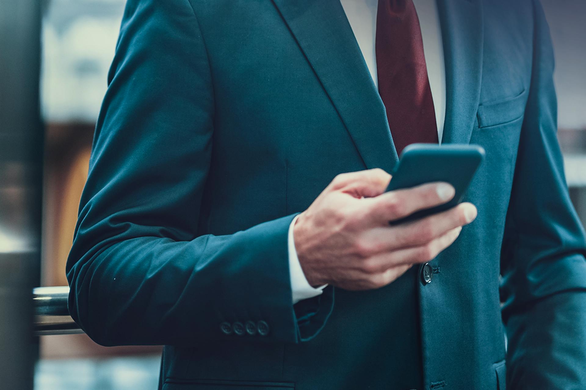 Photo of a business man holding his smartphone