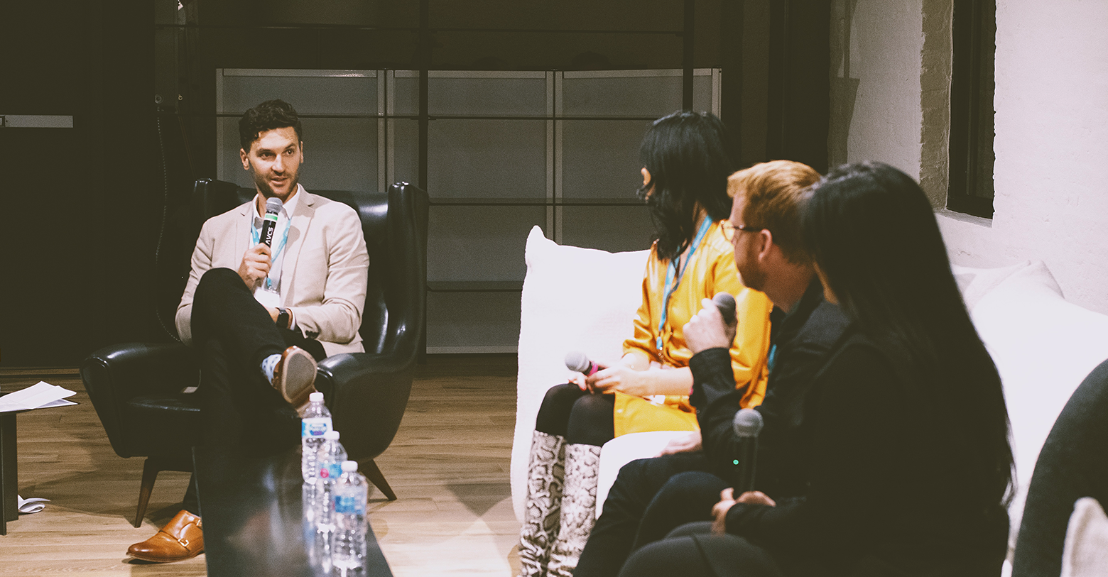 man with a microphone hosting a panel discussion