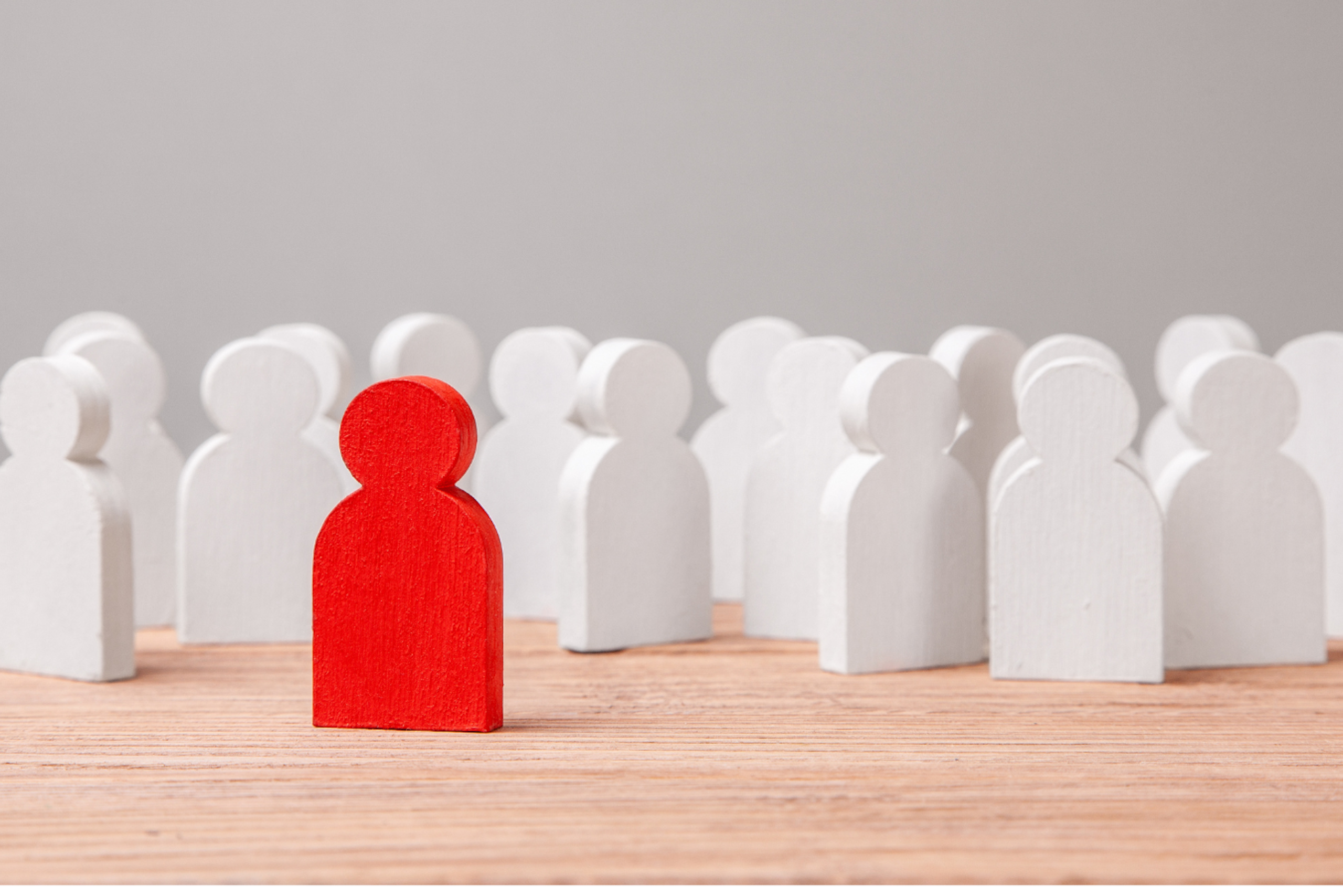 Petit bonhomme rouge autour d'autres petits bonhommes blancs