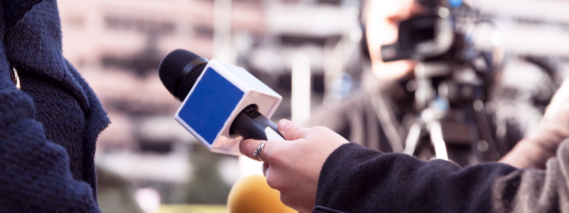 Image of a person holding a microphone out 