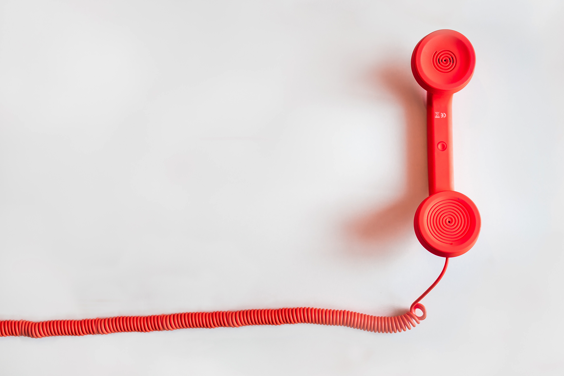 Red telephone against a white background