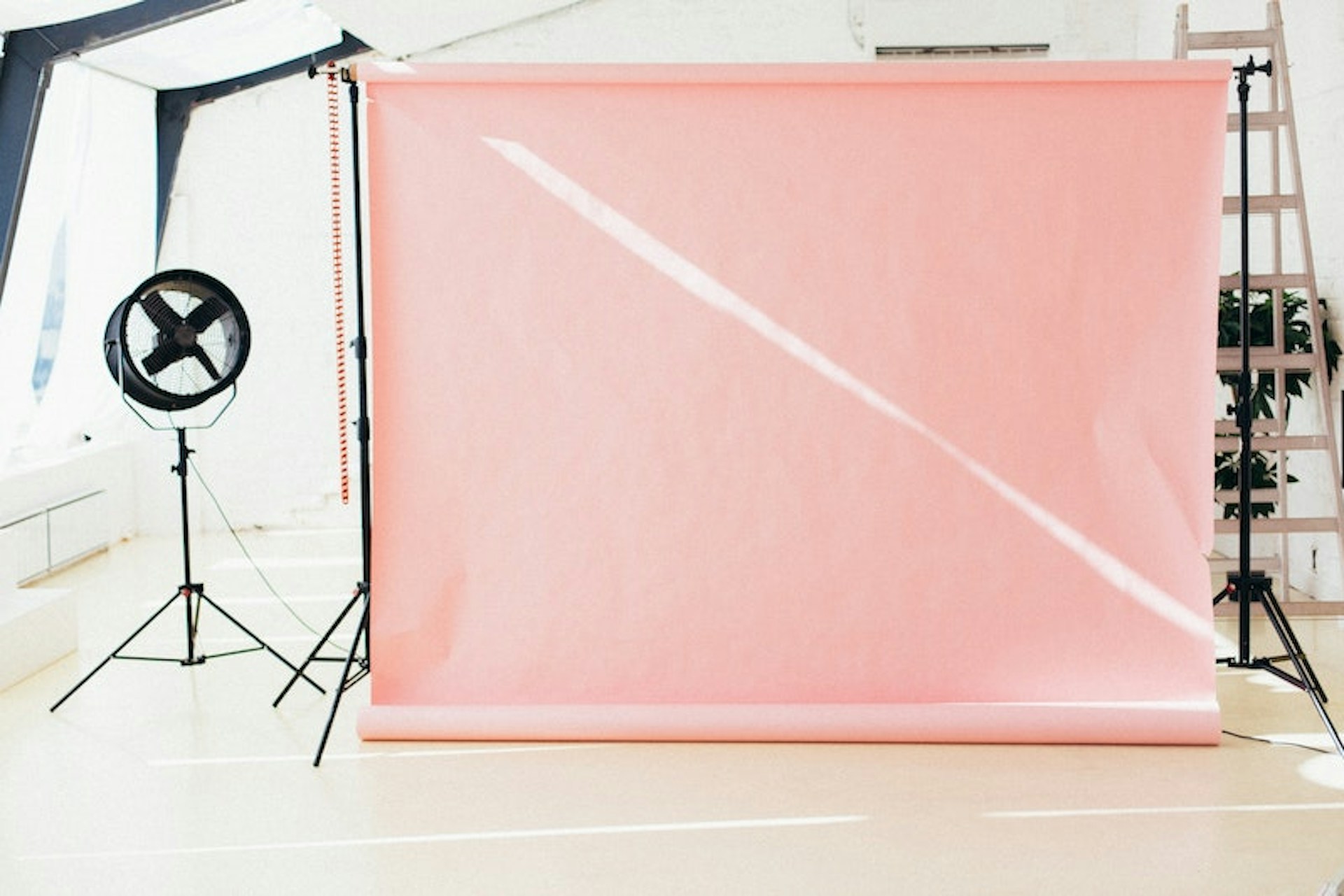 A photo studio with a fan and a light pink background. When gathering competitive data, you should also focus on marketing campaigns and promotions of your competitor.