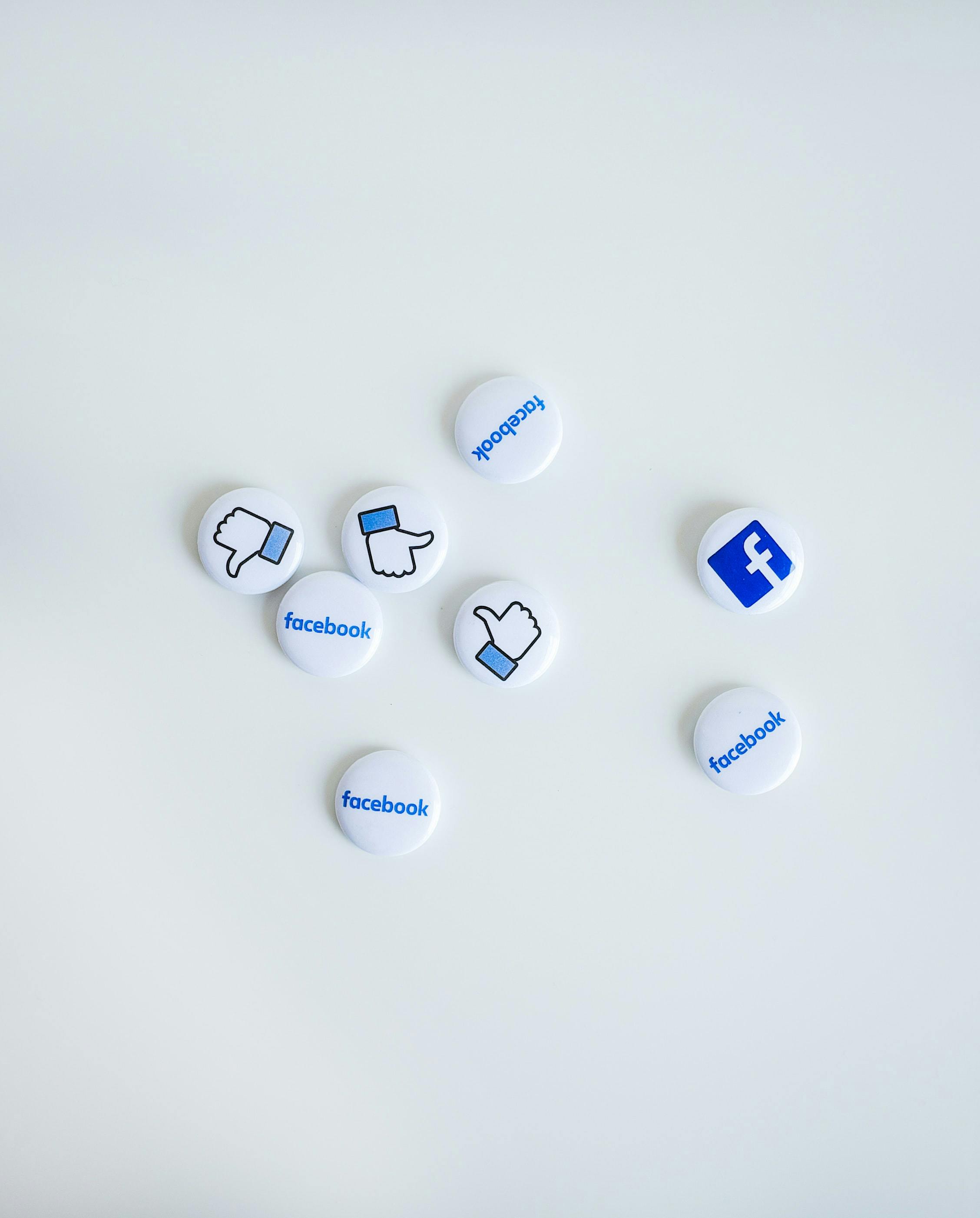 facebook logo and like button on white thumbnails on a white table