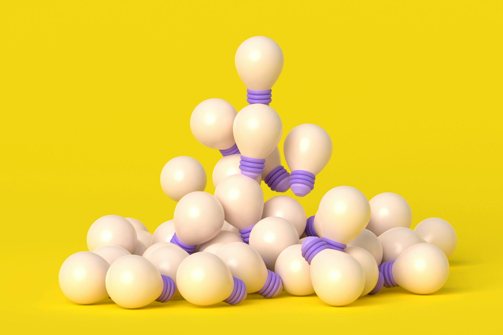 A pile of lightbulbs against a yellow background in this image for a blog about Meltwater's Devopsicon unconference.