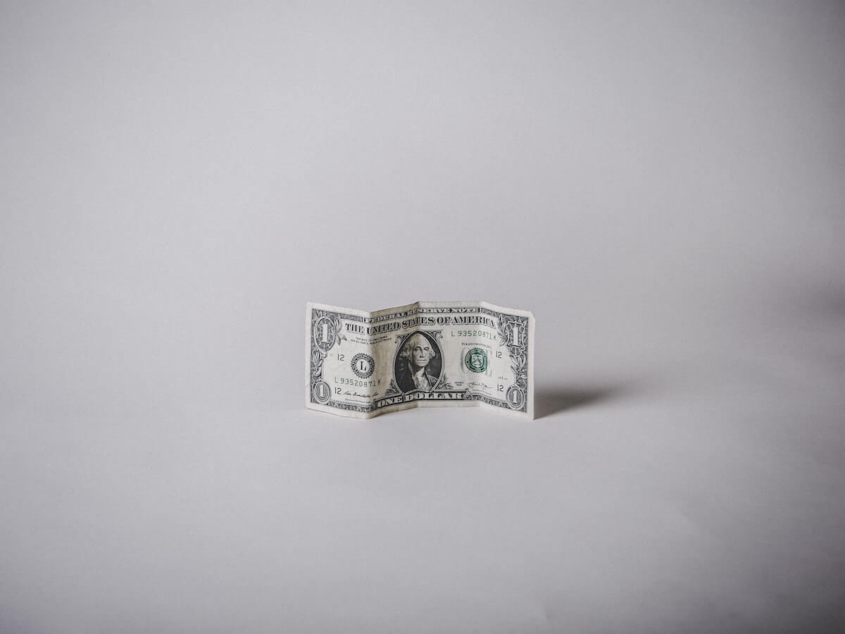 1 US dollar banknote against a white background for showcasing how much media monitoring costs