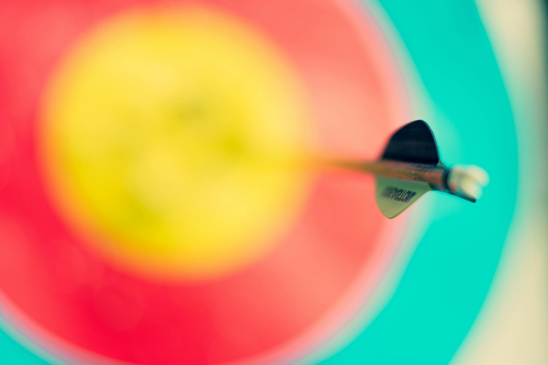 A yellow, red and blue target with a dart in the middle.