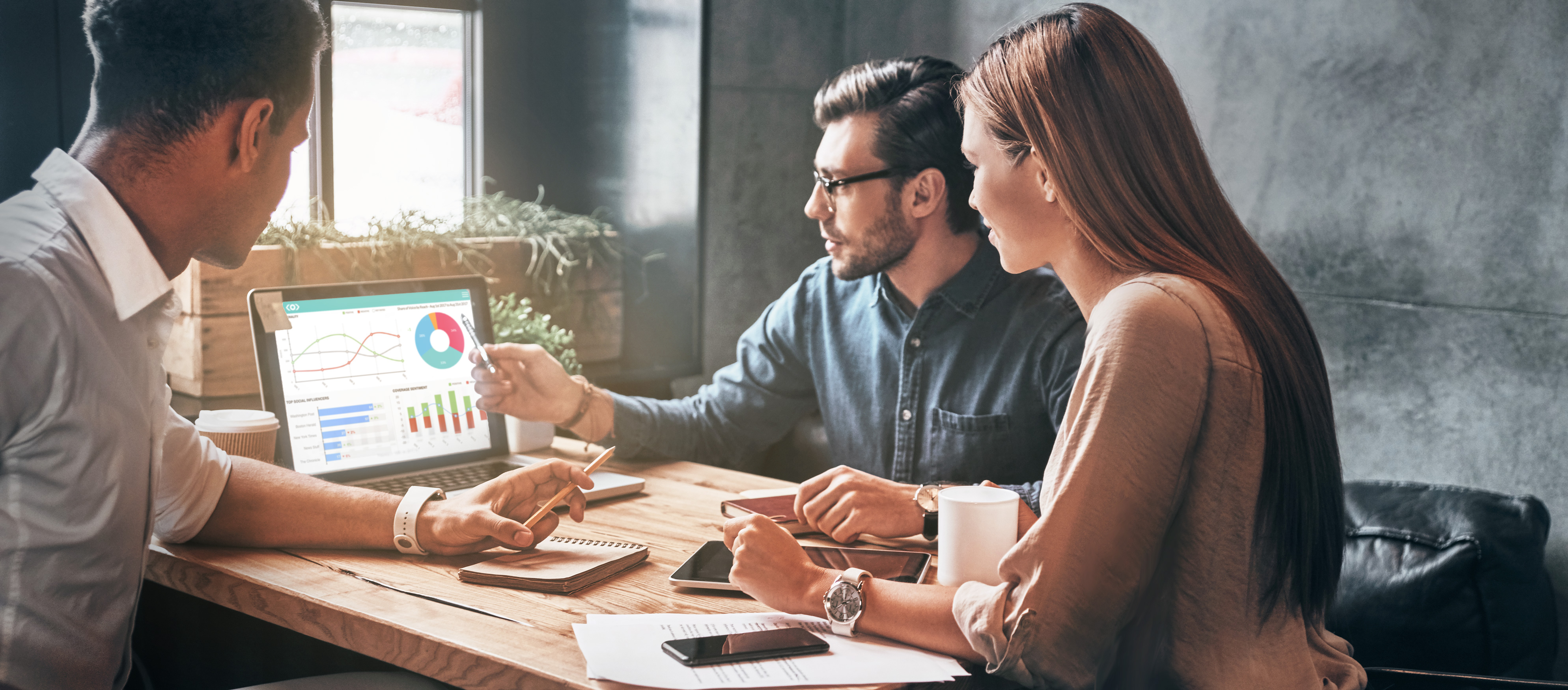 people looking at laptop screen for media monitoring and data analysis