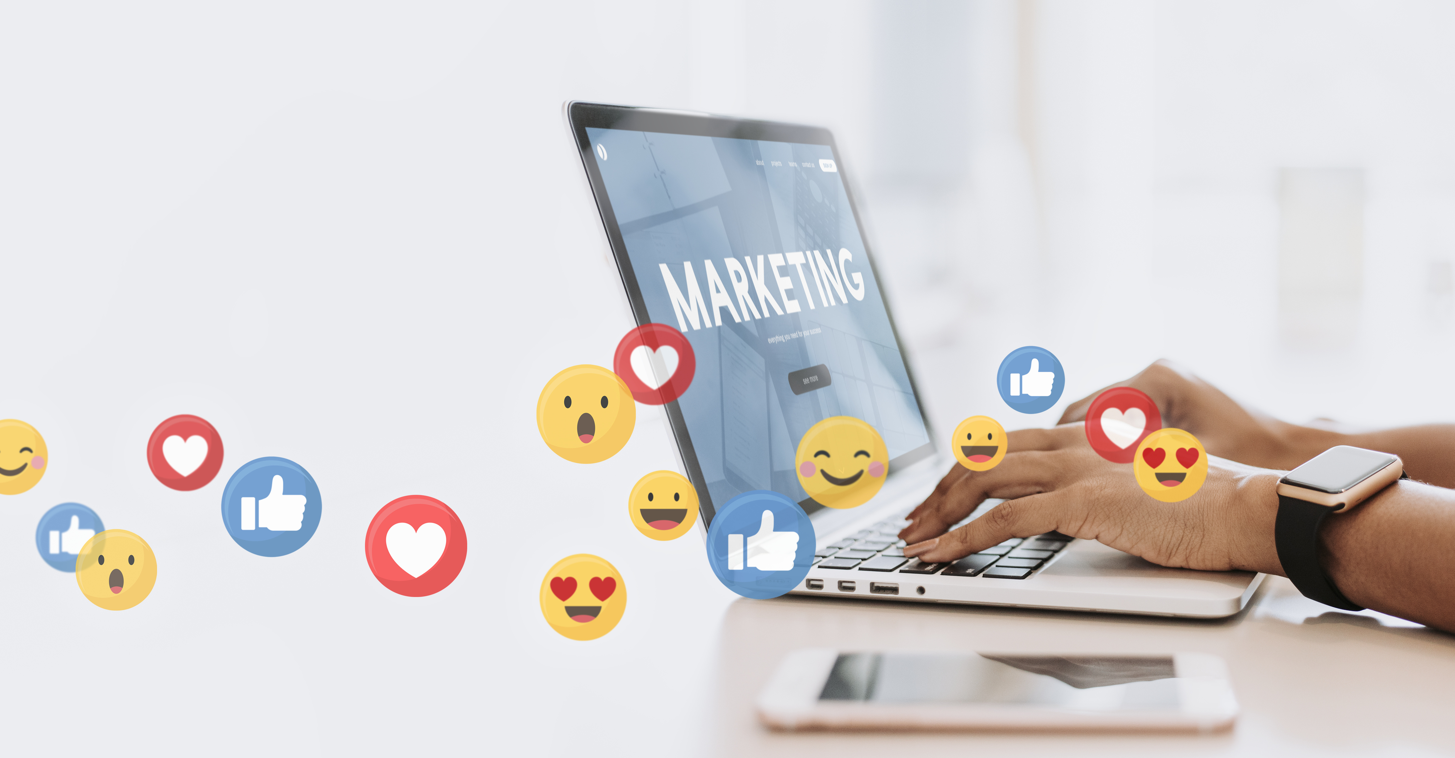 Personne qui tape avec ses mains sur un ordinateur avec écrit Marketing et des emojis