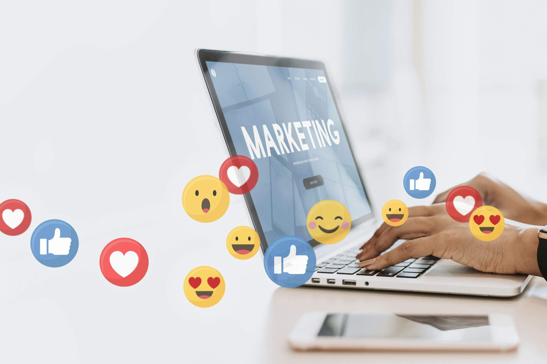 Personne qui tape avec ses mains sur un ordinateur avec écrit Marketing et des emojis