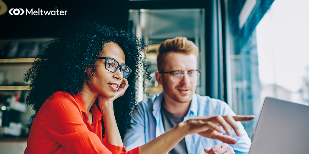 A man and a woman gathered by a laptop