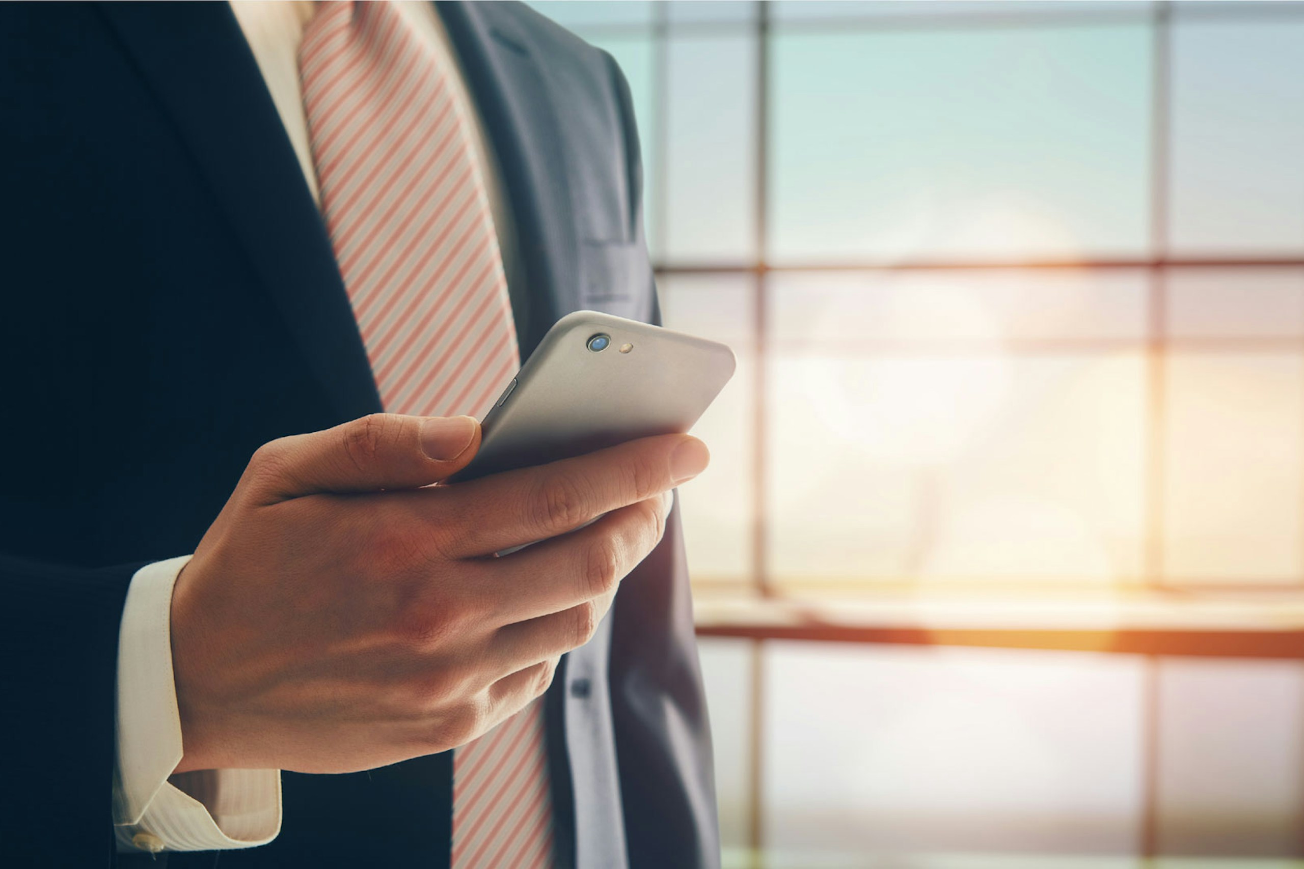 Photo of a business man holding a smartphone