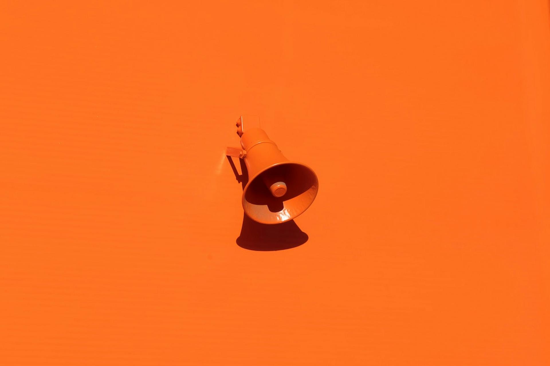 An orange megaphone on an orange surface