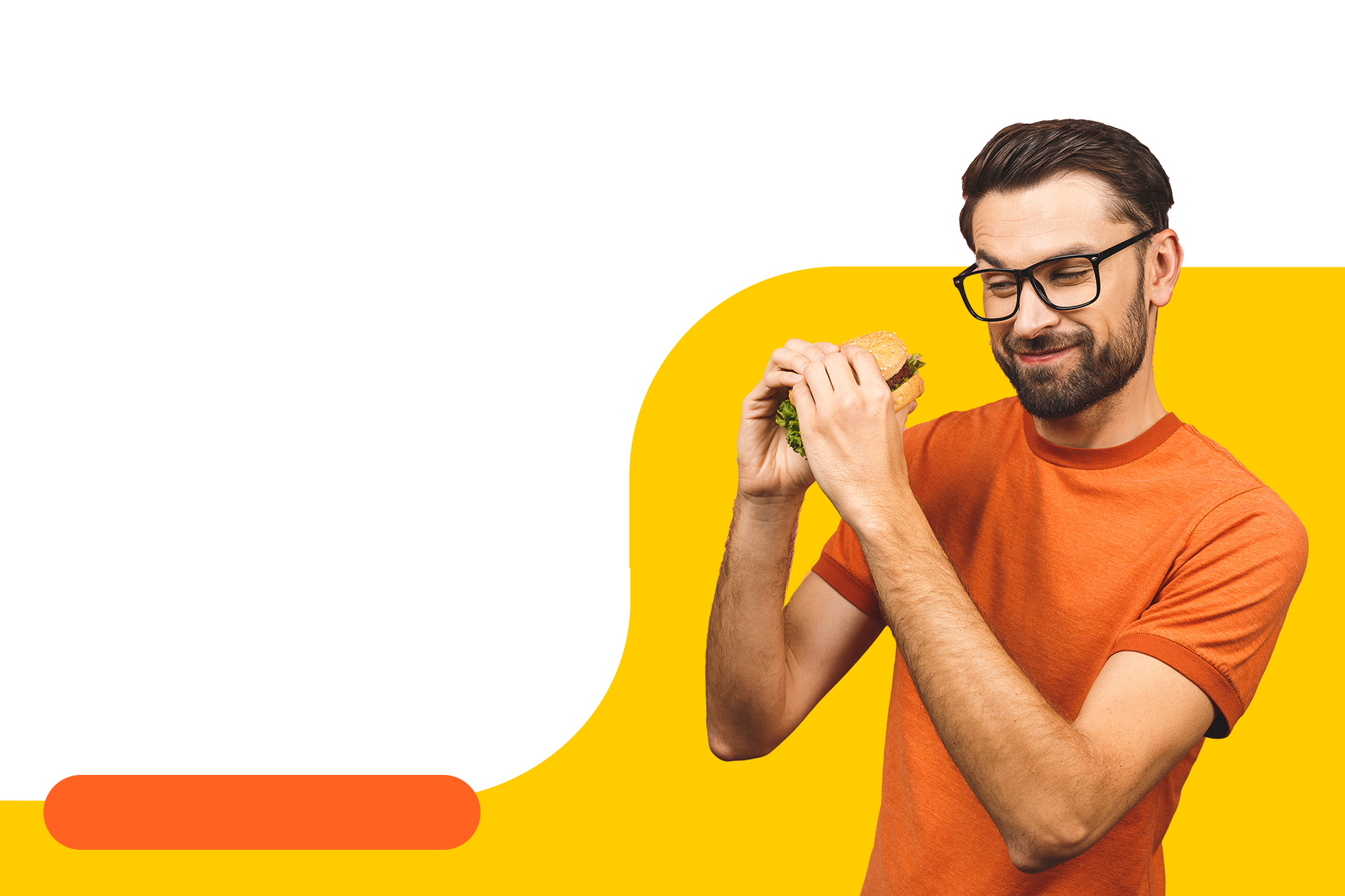 A man wearing an orange shirt on a yellow background, about to eat a sandwich