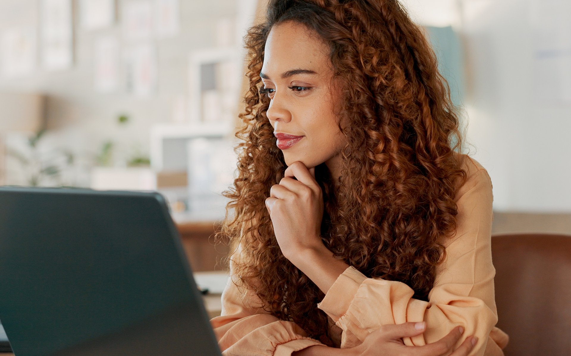 Woman looking with curiosity at a laptop on her desk