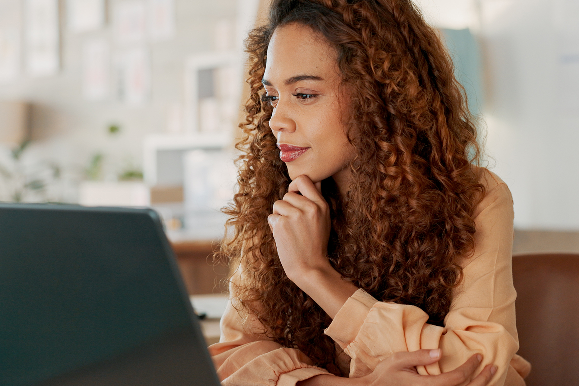 Woman looking with curiosity at a laptop on her desk