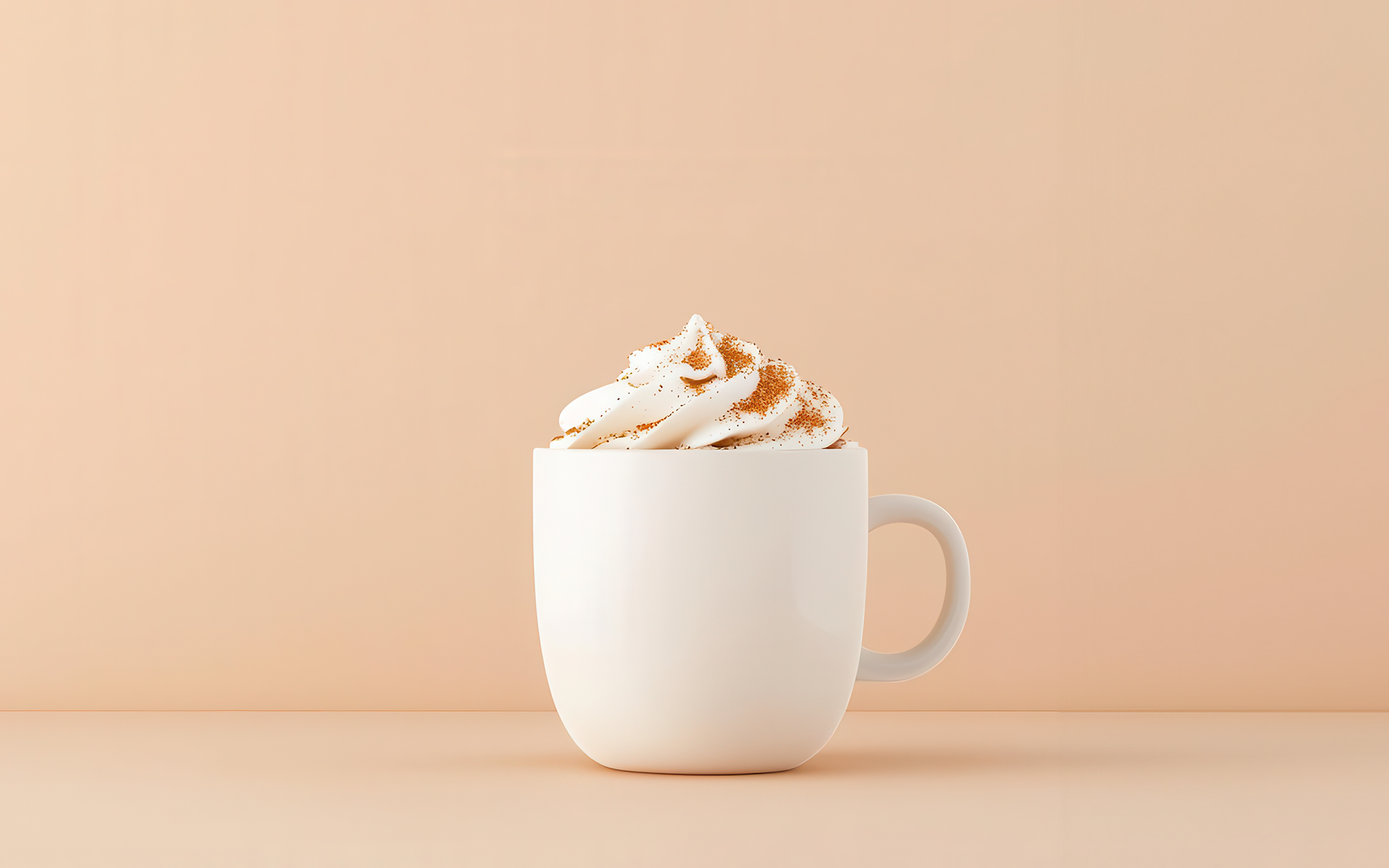 A white mug topped with a swirl of whipped cream stands against a peach background in this image for a Meltwater data blog about pumpkin spice lattes and holiday marketing calendars