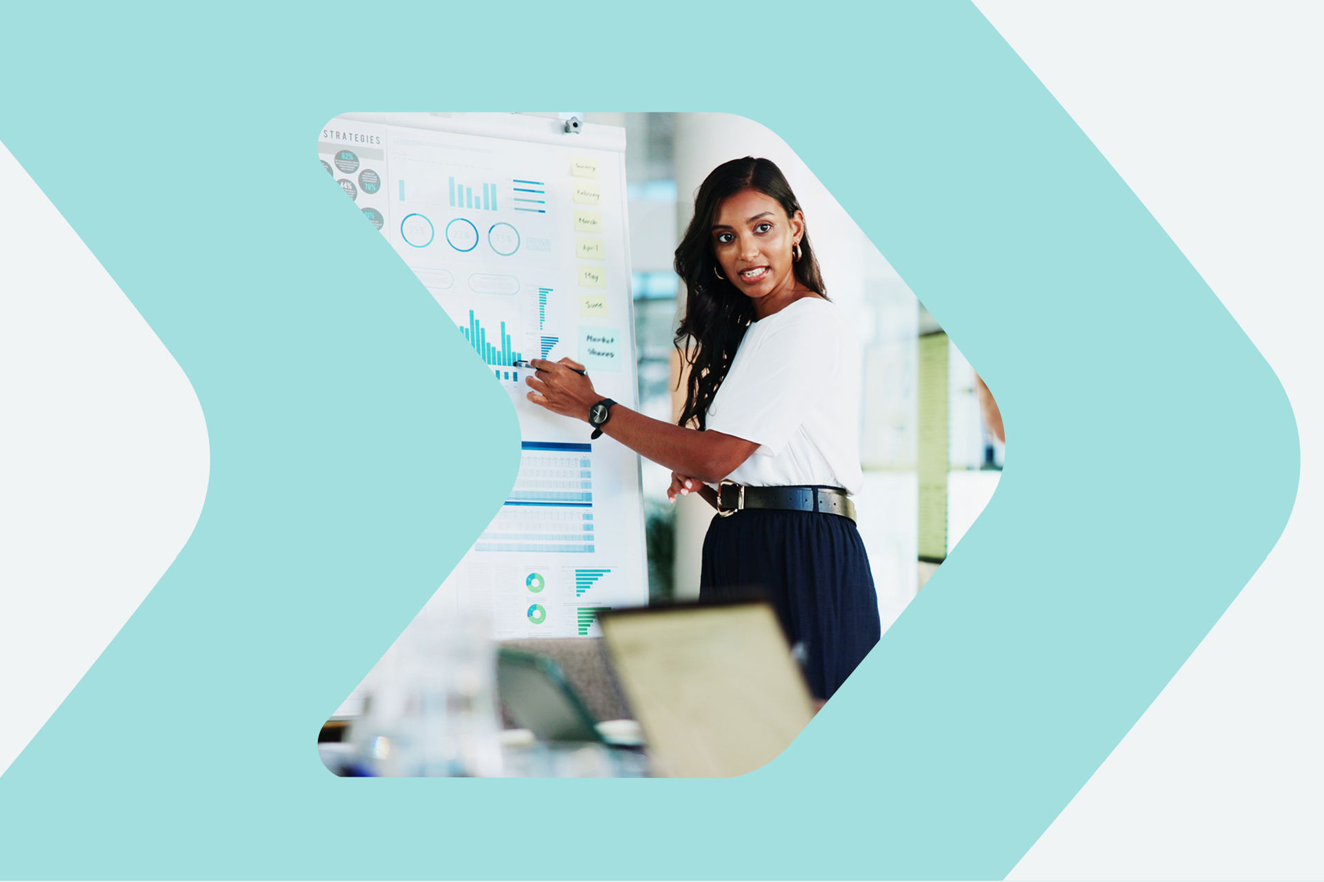 A woman standing at a whiteboard giving a presentation with results of media monitoring for a large organization. Ultimate Guide to Media Monitoring ebook.