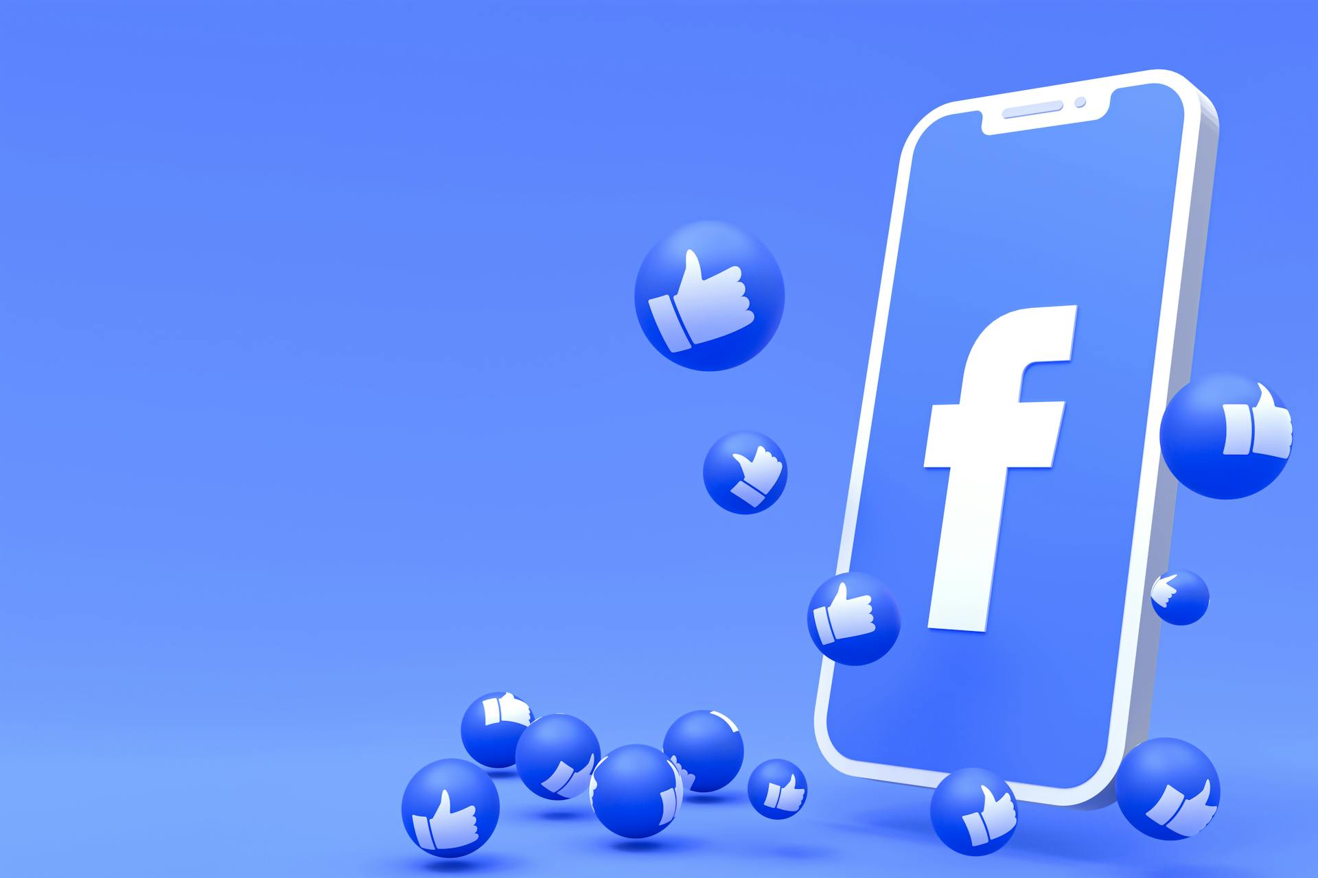 Blauer Hintergrund, davor ein Smartphone mit Facebook-Logo auf dem Bildschirm und rundherum sind blaue Blasen auf denen man einen "Daumen-hoch" sieht