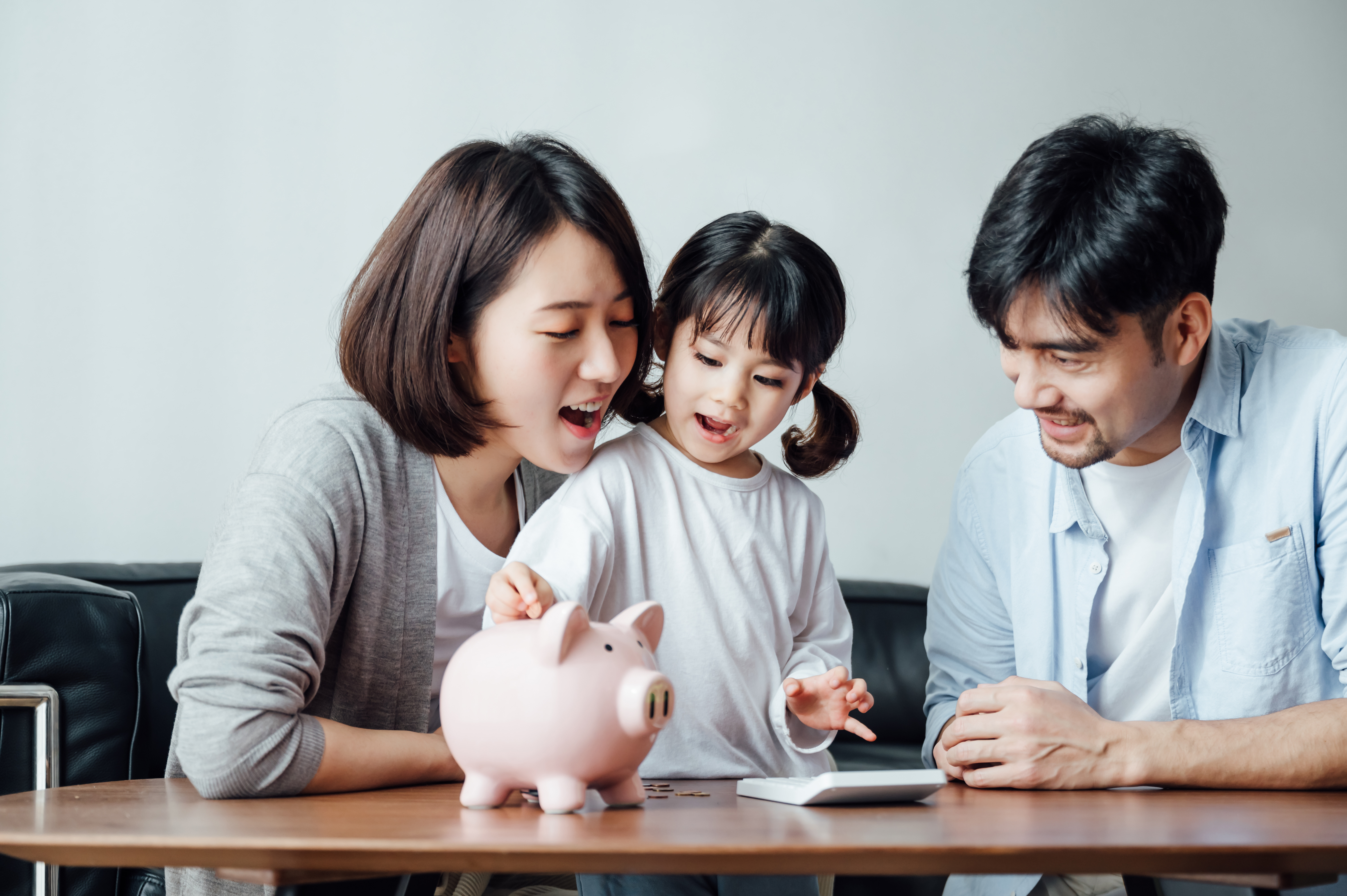 Photo showing a family from Singapore sitting at a table with a piggy bank. 2023 Industry Snapshot: Banking and Financial Services in Singapore