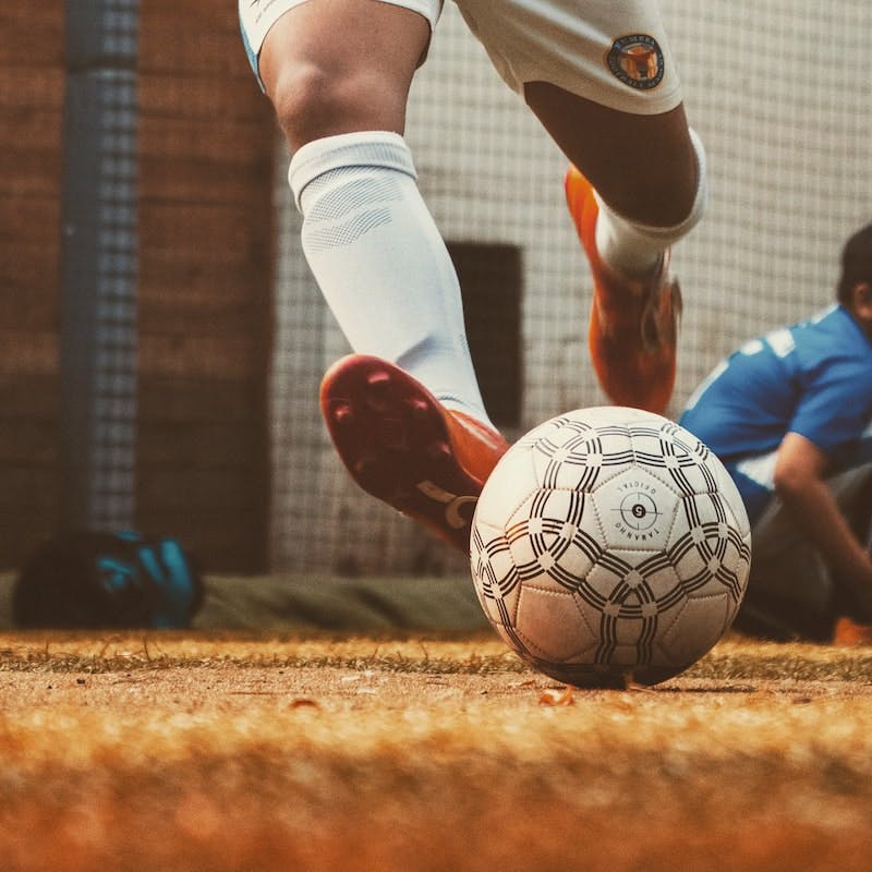 A football player kicking a ball. CI is also often used in sport analytics. Some football teams overcome financial disadvantages and outperform competitors because they are very successful in collecting competitive data and distributing this information among the executive level.