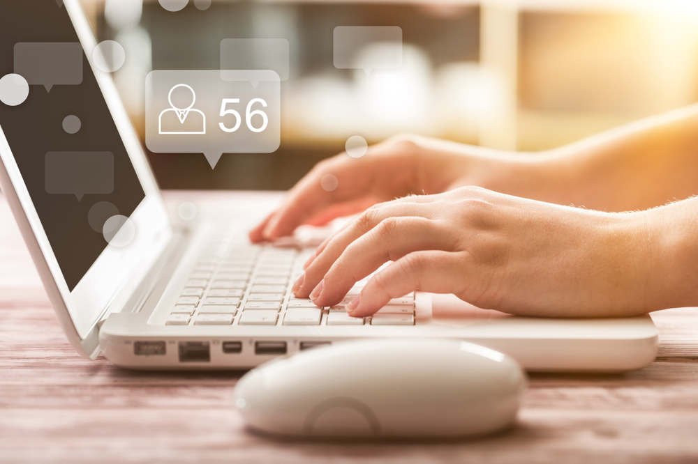 hands typing into laptop