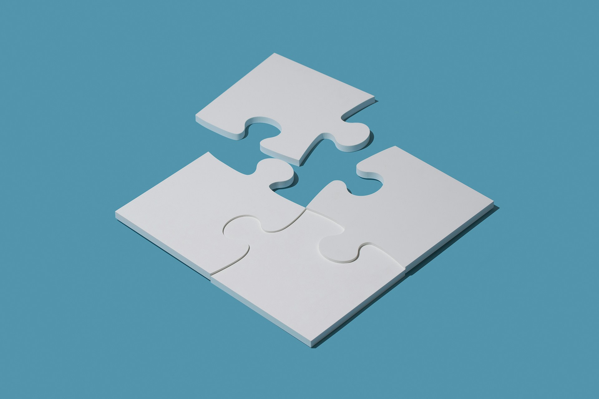 A 4-piece puzzle in the shape of a square with one corner not yet connected on a blue background. This image is being used a thumbnail for a blog onmarketing segementation