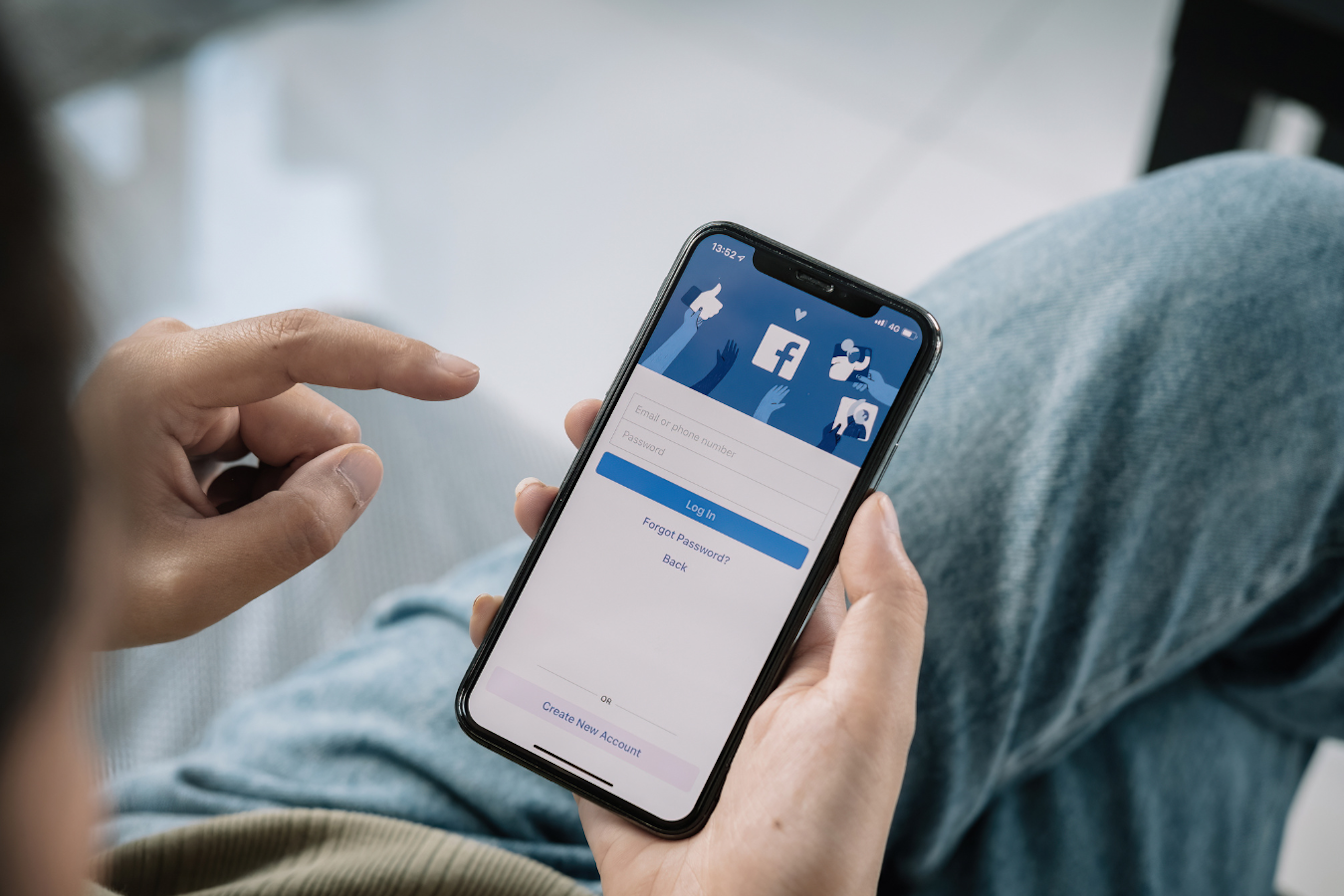 une personne qui tient un téléphone avec l'application Facebook
