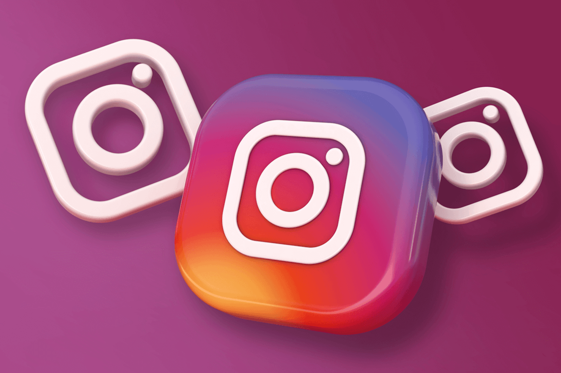 Kuvassa on suuri Instagram-logo värillisenä ja kaksi pienempää Instagram-logoa valkoisella molemmin puolin tummalla violetilla taustalla. B2B Instagram-tili esimerkkejä blogikirjoitus.
