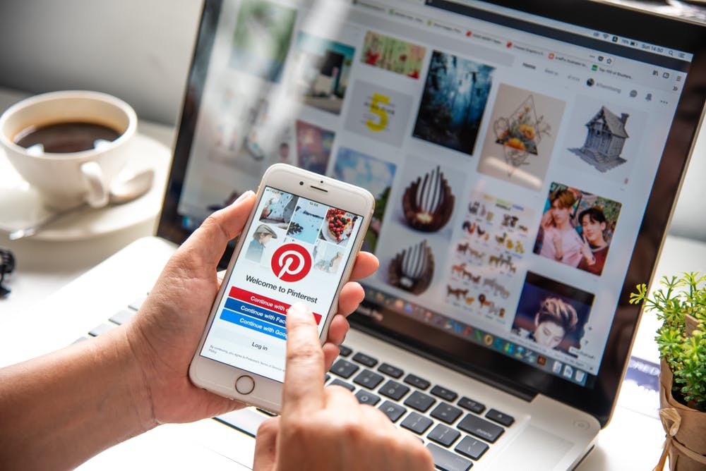 Mit Kaffe vor Laptop und Smartphone mit Pinterest