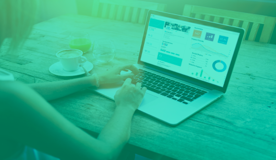 Foto von Frau, die an ihrem Laptop arbeitet mit einem offenen Dashboard an Daten