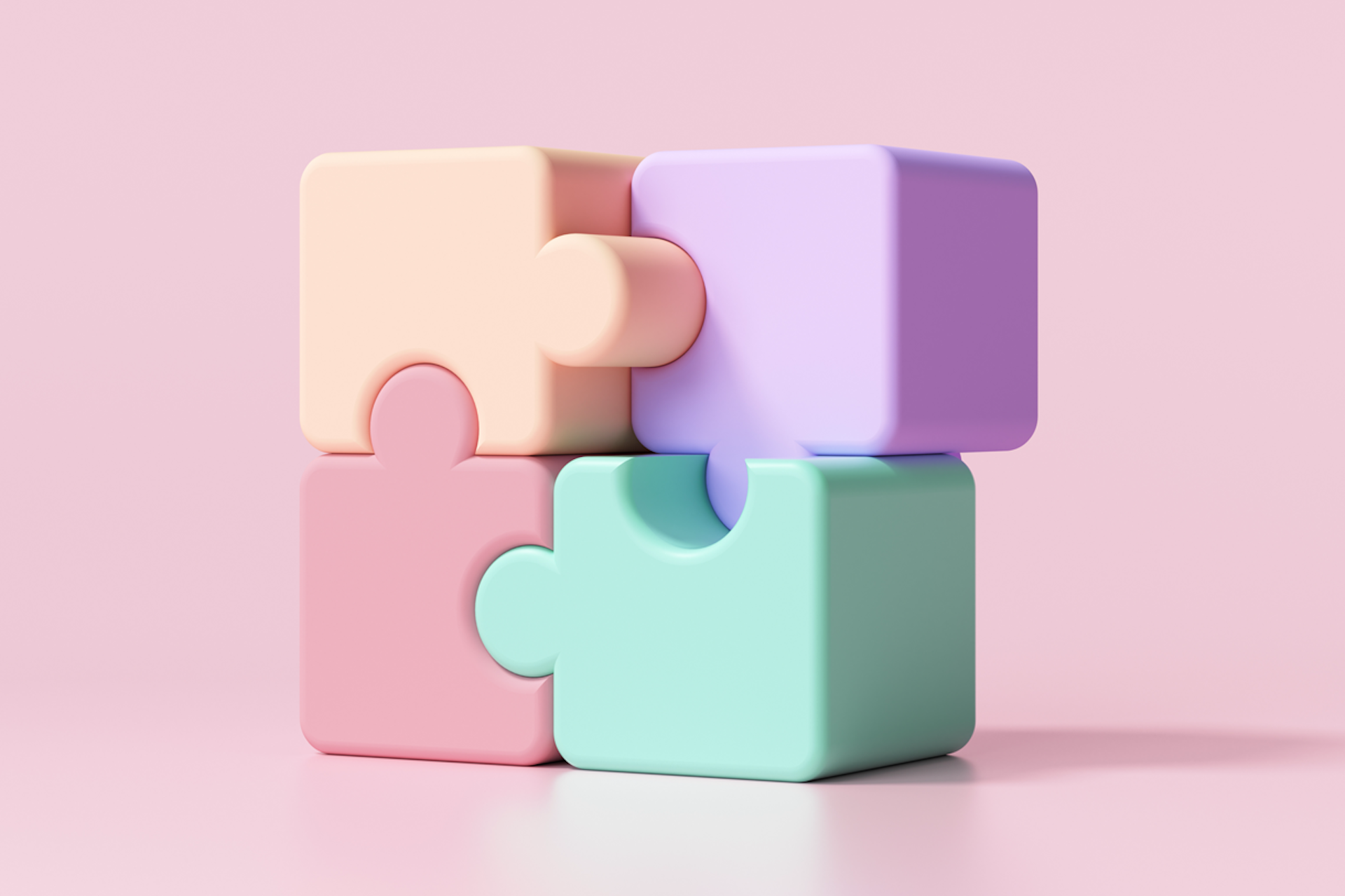 Four puzzle pieces that are all connected, like the perfect team. This image is being used as the header image for a blog that describes How To Build An Effective Team.