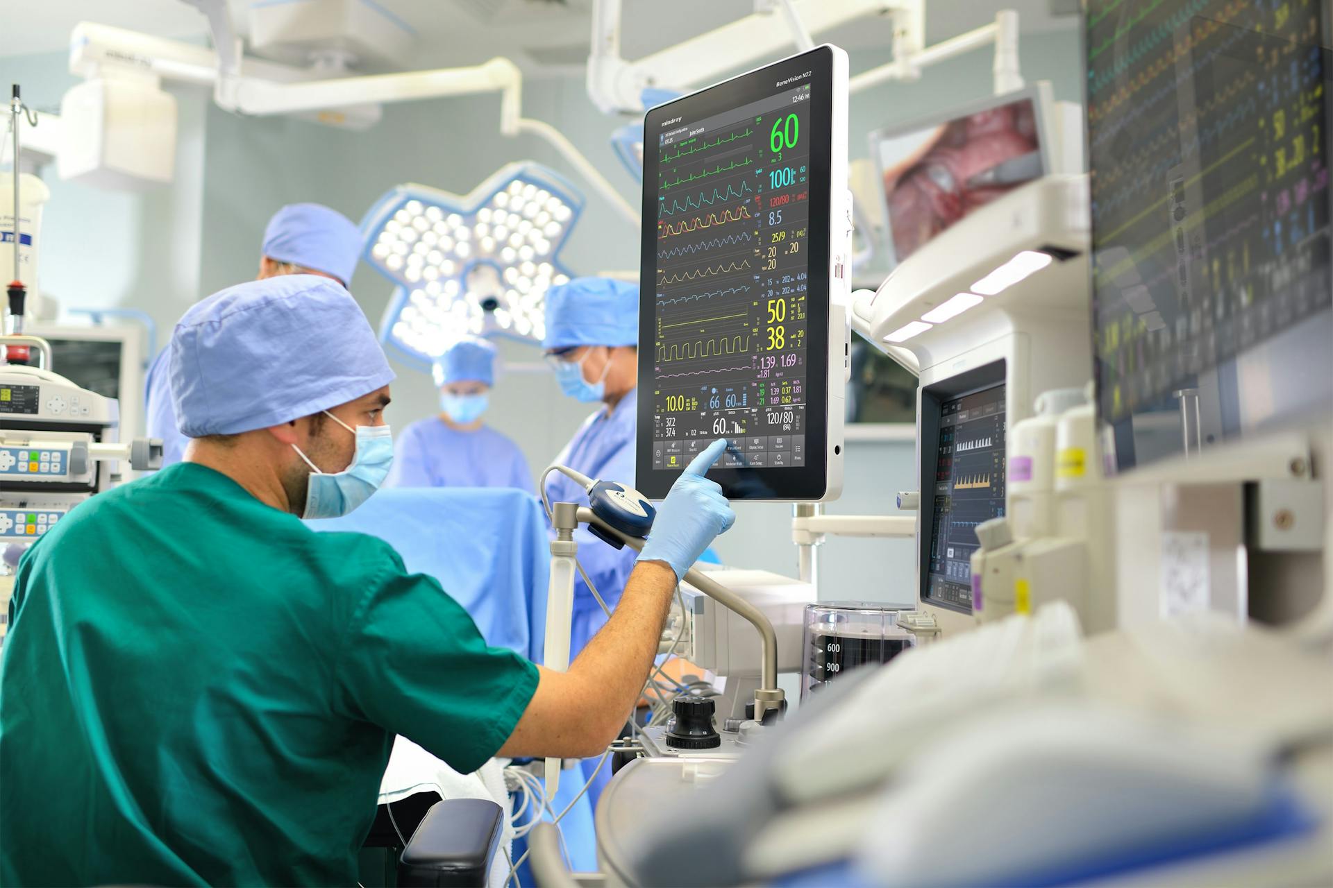 Medical staff in surgery looking at a patient's vital signs