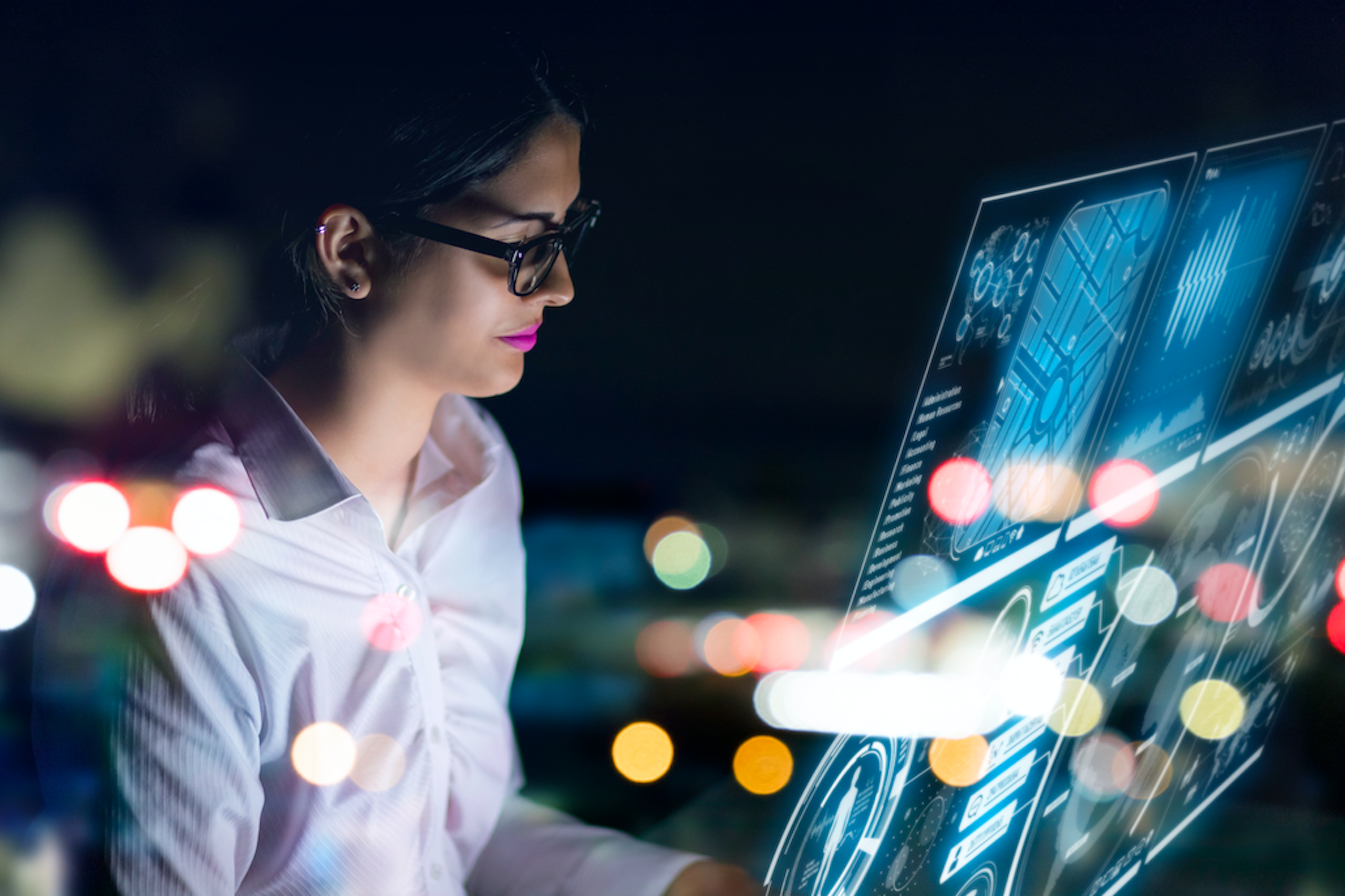 woman wearing glasses and working on a computer screen
