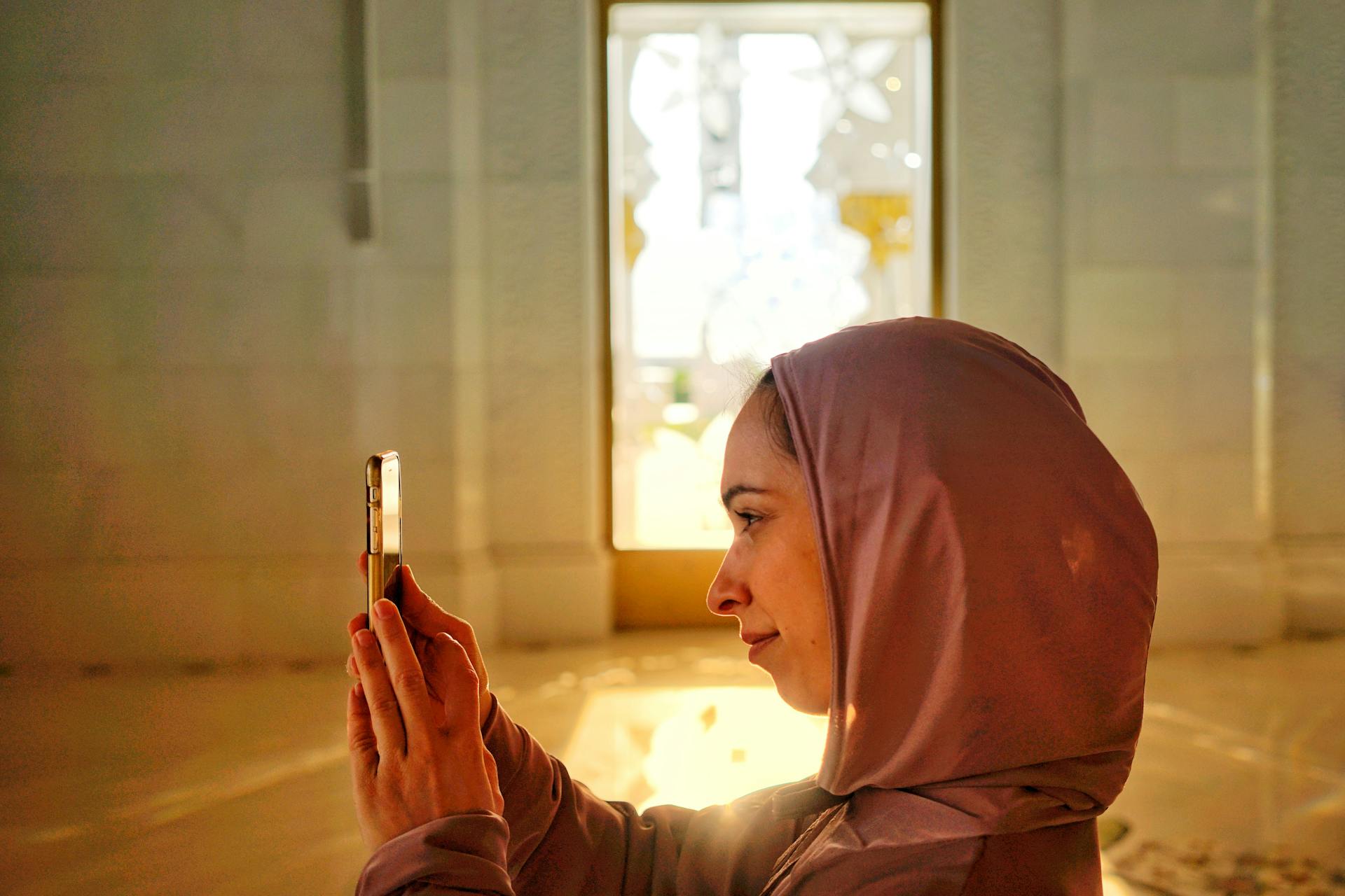 阿拉伯妇女拿着她的智能手机拍照